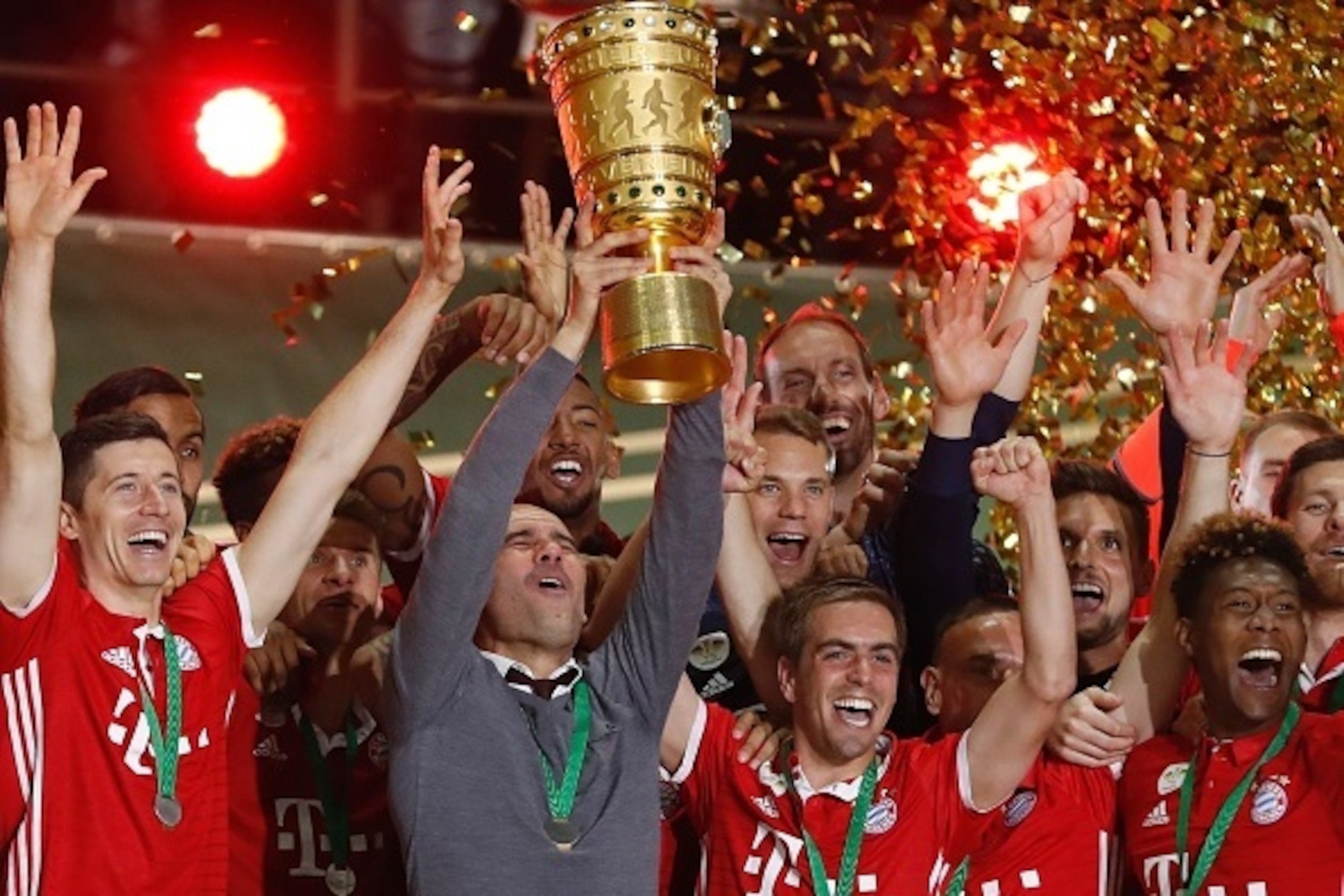 Bayern Munich's Spanish head coach Pep Guardiola lifts the trophy as he and his players celebrate winning the German Cup (DFB Pokal) final football match Bayern Munich vs Borussia Dortmund at the Olympic stadium in Berlin on May 21, 2016. / AFP / ODD ANDE