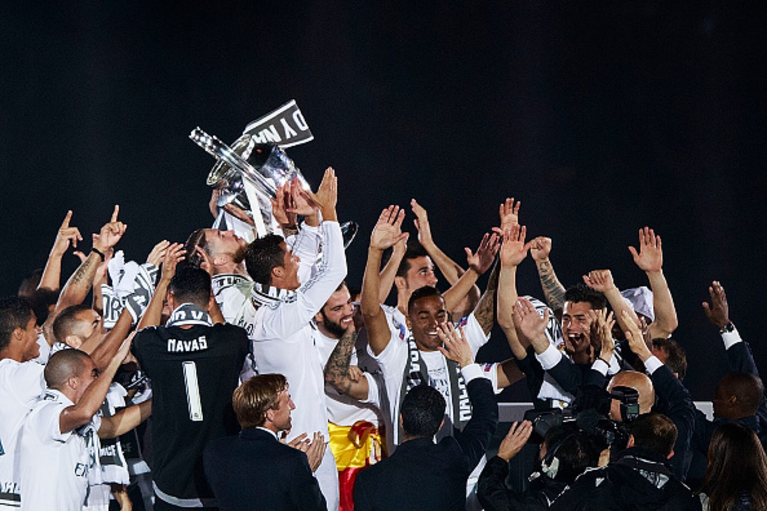 MADRID, SPAIN - MAY 29: Captain Sergio Ramos of Real Madrid CF holds the trophy behind Cristiano Ronaldo as they offer it to the audience surrounded by their teammates at Santiago Bernabeu Stadium the day after winning the UEFA Champions League Final matc