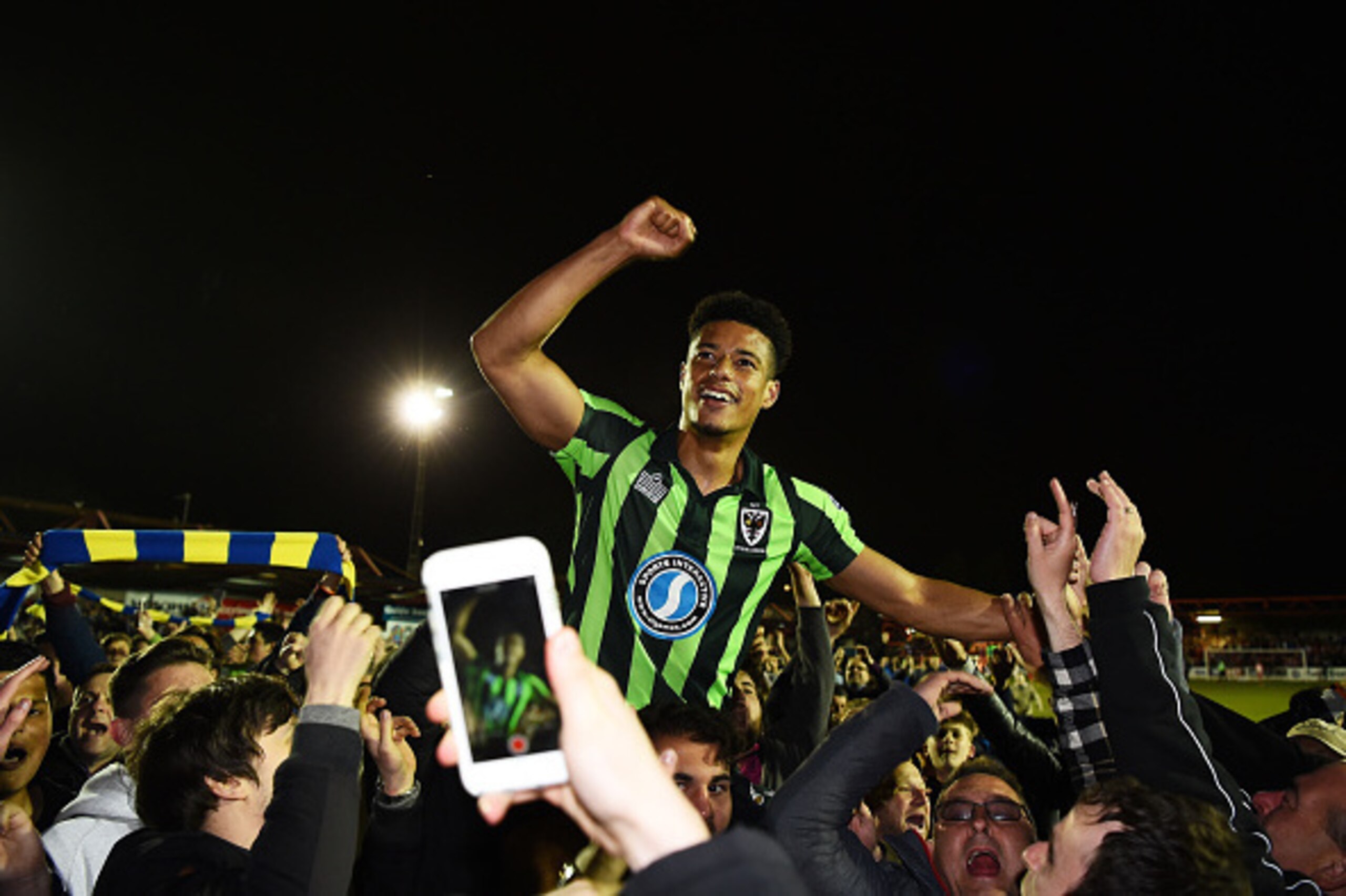 ACCRINGTON, ENGLAND - MAY 18:  Tie winning goalscorer Lyle Taylor of AFC Wimbledon is carried aloft by the fans after their team wins promotion to League One during the Sky Bet League Two play off, Second Leg match between Accrington Stanley and AFC Wimbl
