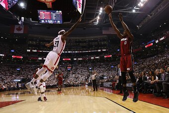 TORONTO,ON - MAY 15 2016:  Josh Richardson #0 of the Miami Heat makes a 3 point shot as Terrence Ross #31 of the Toronto Raptors guards him during Game Seven of the NBA Eastern Conference Semi Finals at Air Canada Centre on May 15, 2016 in Toronto, Ontari