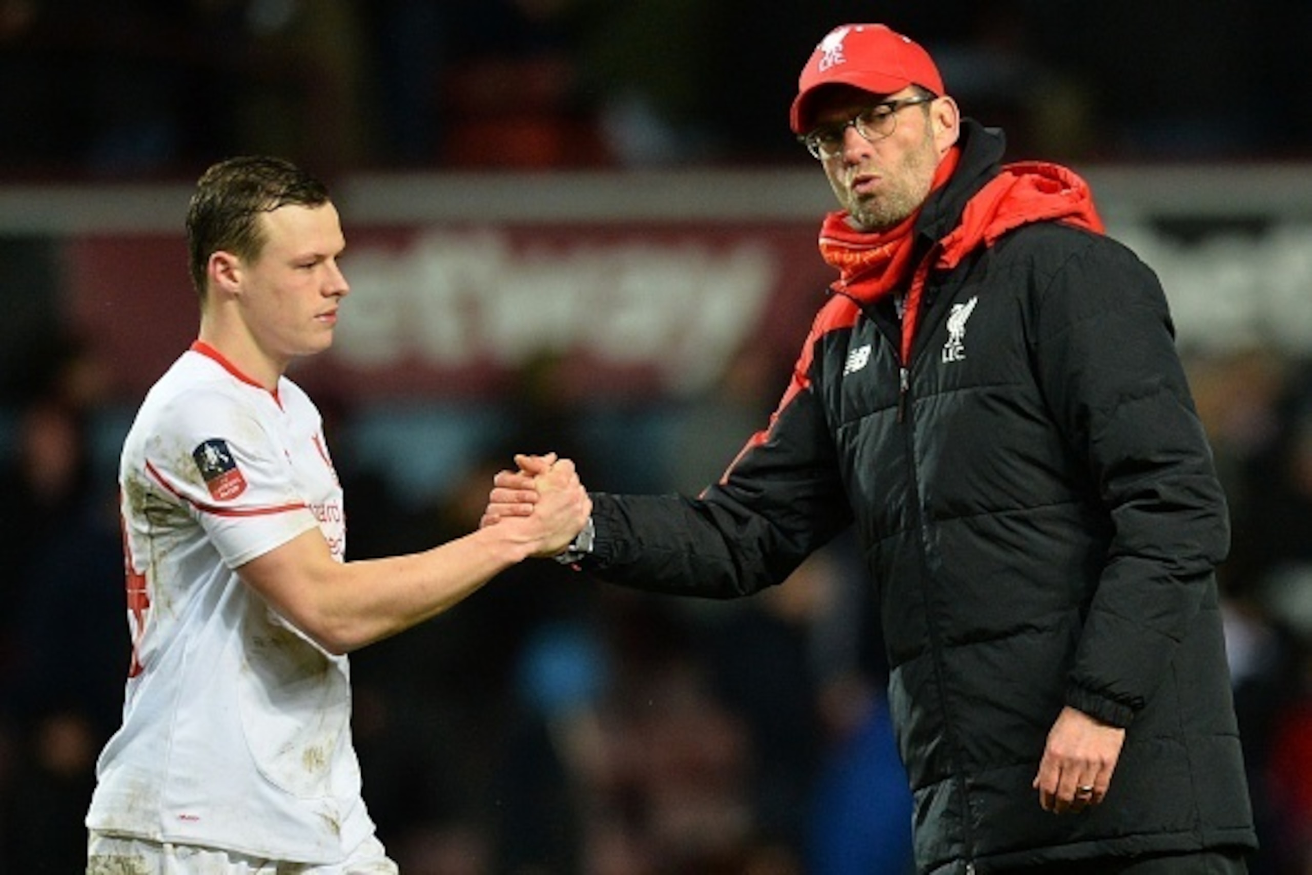 Liverpool's German manager Jurgen Klopp (R) shakes hands with Liverpool's Australian defender Brad Smith after the English FA Cup fourth round replay football match between West Ham United and Liverpool at The Boleyn Ground in Upton Park, east London, on 