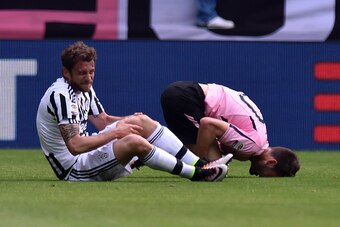TURIN, ITALY - APRIL 17:  Claudio Marchisio (L) of Juventus and Franco Vazquez of Palermo lie on the pitch after an injury during the Serie A match between Juventus FC and US Citta di Palermo at Juventus Arena on April 17, 2016 in Turin, Italy.  (Photo by