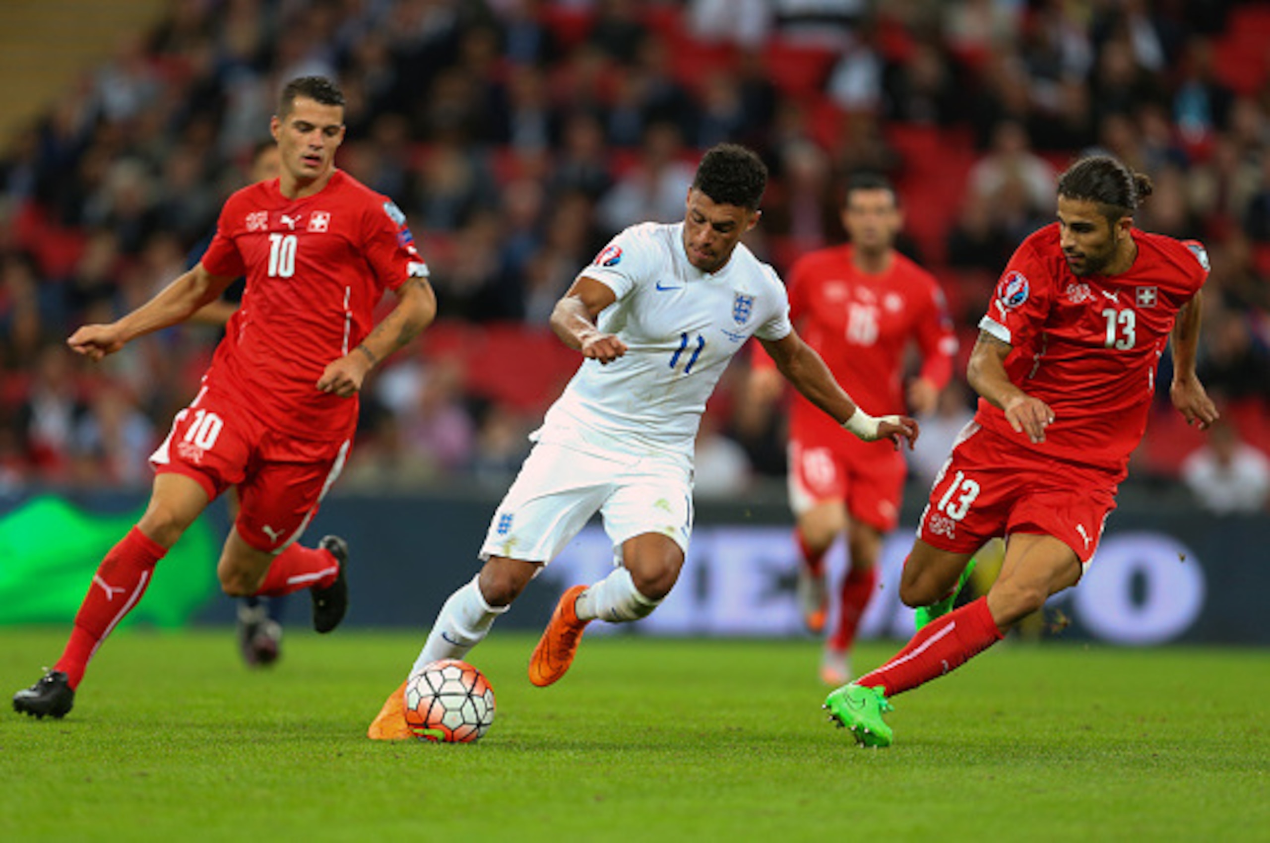 LONDON, ENGLAND - SEPTEMBER 08:  Alex Oxlade-Chamberlain of England gets away from Granit Xhaka and Ricardo Rodriguez of Switzerland during the UEFA Euro 2016 Qualifier Group E match between England and Switzerland at Wembley Stadium on September 8, 2015 