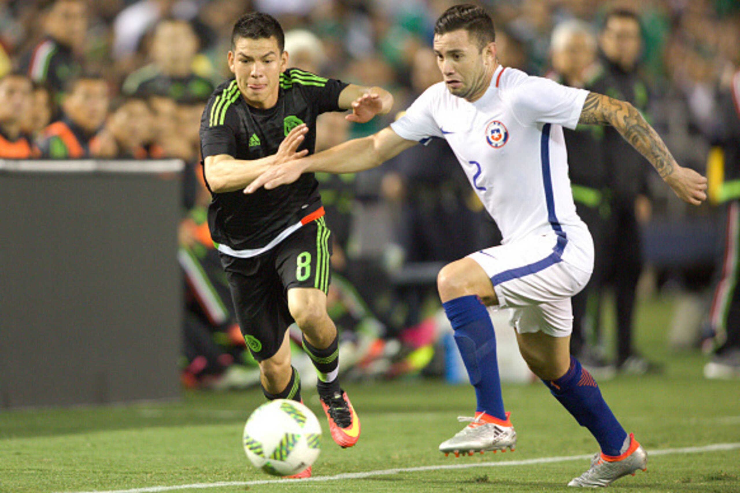 Hirving Lozano of Mexico (L) vies for the ball with Eugenio Mena (R) of Chile during the friendly match between the Mexican national team and Chile national team at the Qualcomm Stadium, on June 1st, 2016, in San Diego, California.  / AFP / VICTOR STRAFFO