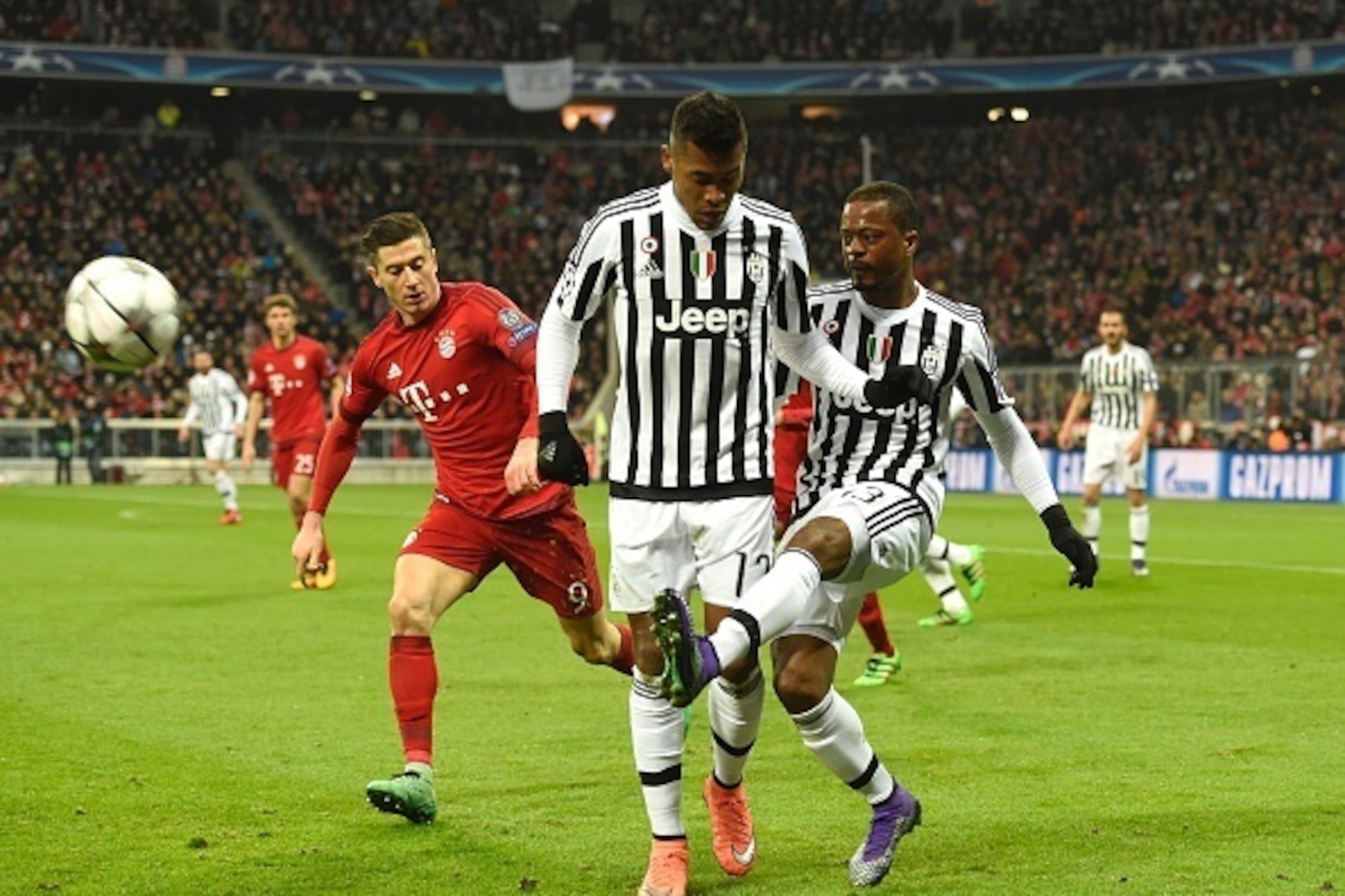 Bayern Munich's Polish striker Robert Lewandowski (L) vies for the ball with Juventus' defender from Brazil Alex Sandro (C) and Juventus' defender from France Patrice Evra  during the UEFA Champions League, Round of 16, second leg football match FC Bayern