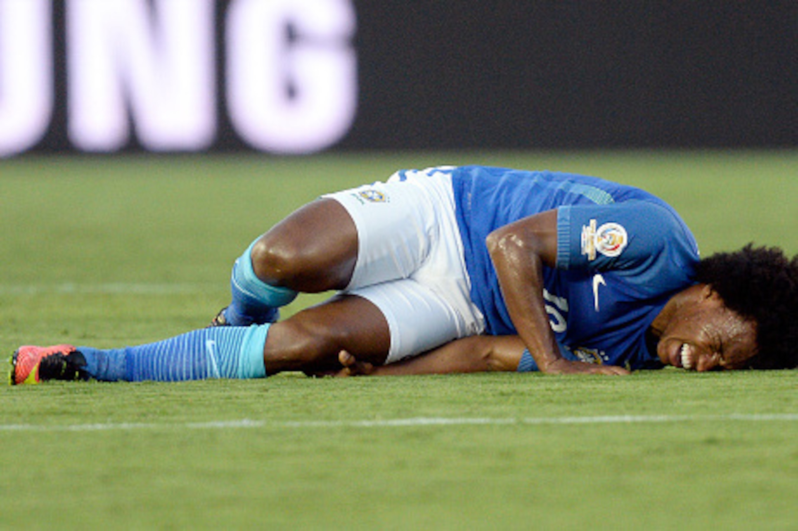 PASADENA CA - JUNE 4: Willian #19 of Brazil grimaces in pain after colliding  with Carlos Gruezo #18 of Ecuador during the first half of the 2016 Copa America Centenario Group B match between Brazil and Ecuador at the Rose Bowl June 4, 2016, Pasadena, Cal