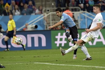 Uruguay's forward Luis Suarez scores a sceond goal as England's next to defender Gary Cahill looks on during a Group D football match between Uruguay and England at the Corinthians Arena in Sao Paulo during the 2014 FIFA World Cup on June 19, 2014. AFP PH