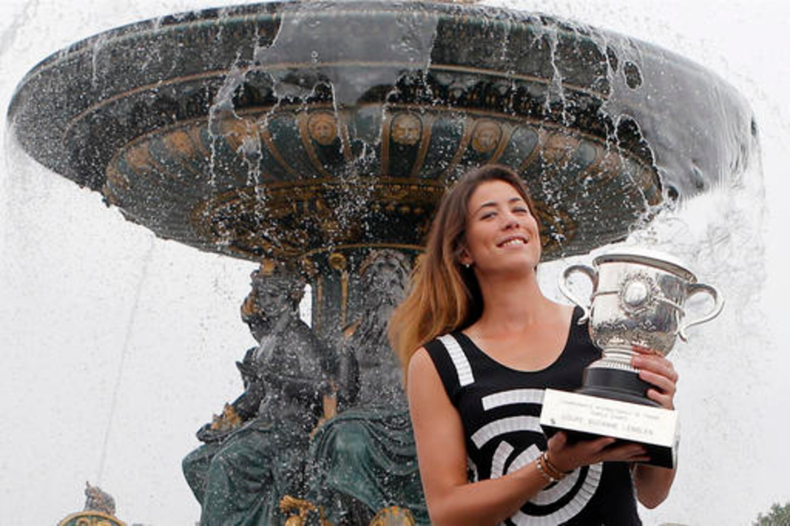 Muguruza poses with her French Open title in Paris.