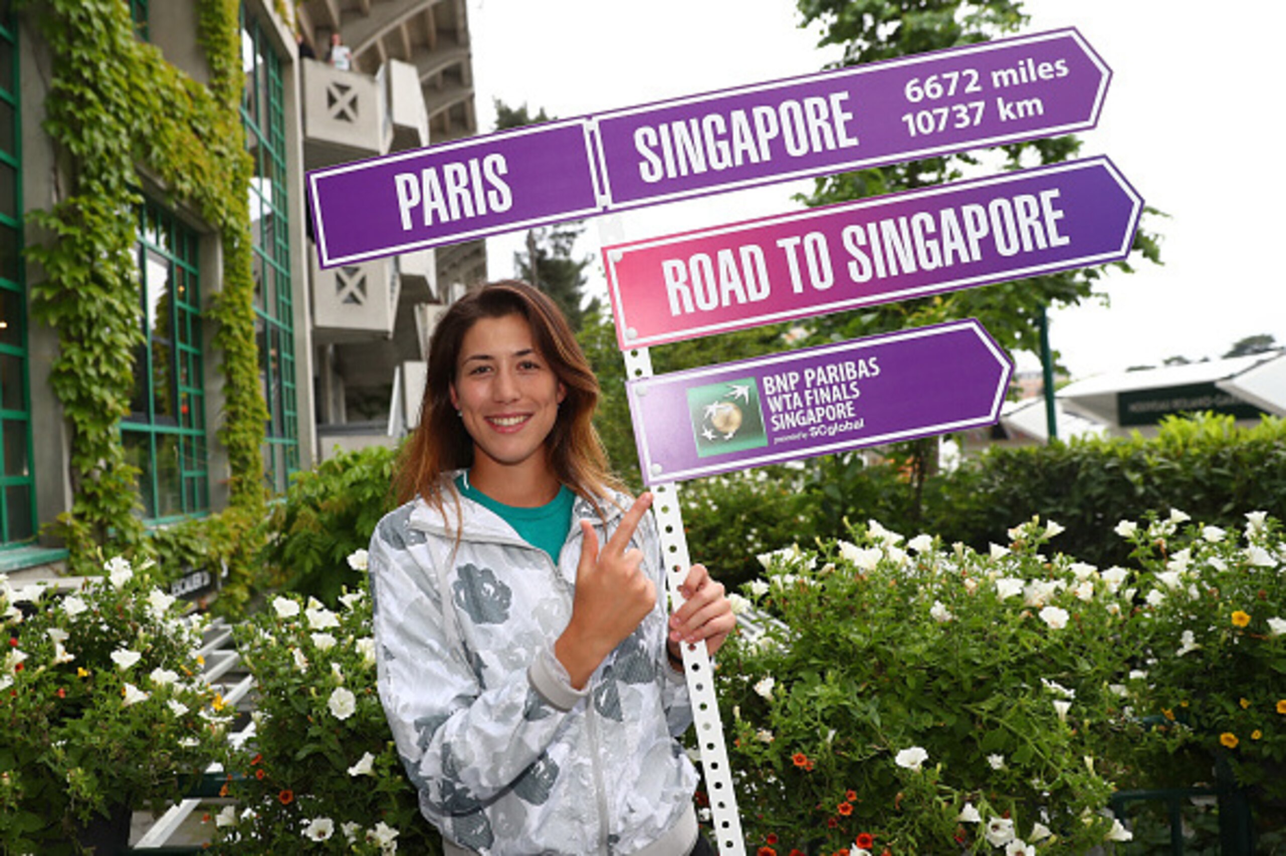 PARIS, FRANCE - JUNE 04:  Ladies Singles champion Garbine Muguruza of Spain holds the Rod To Singapore sign on day fourteen of the 2016 French Open at Roland Garros on June 4, 2016 in Paris, France.  (Photo by Julian Finney/Getty Images)