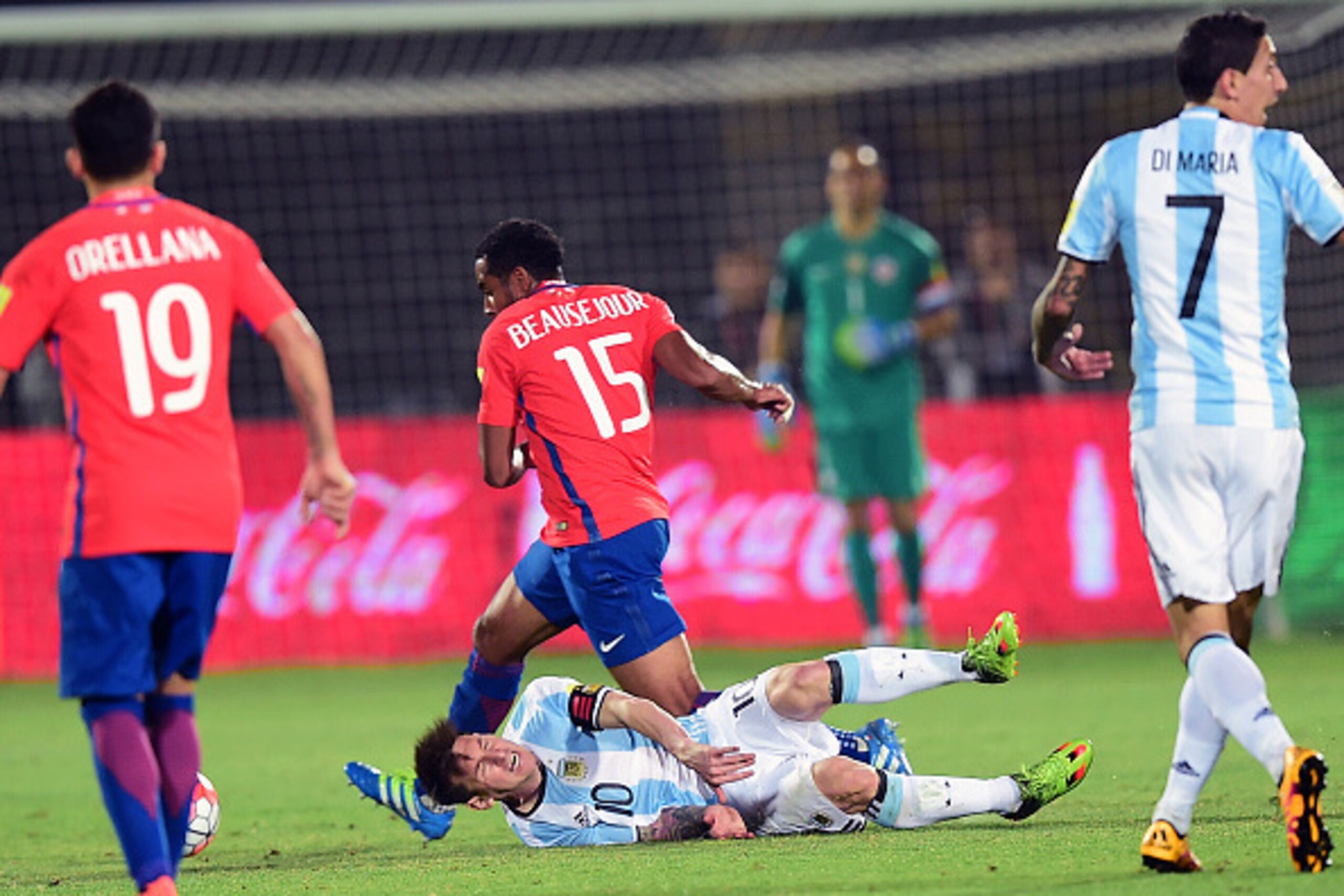 Argentina's Lionel Messi (10) falls next to Chile's Jean Beausejour during their Russia 2018 FIFA World Cup South American Qualifiers' football match, in Santiago on March 24, 2016.   AFP PHOTO / MARTIN BERNETTI / AFP / MARTIN BERNETTI        (Photo credi