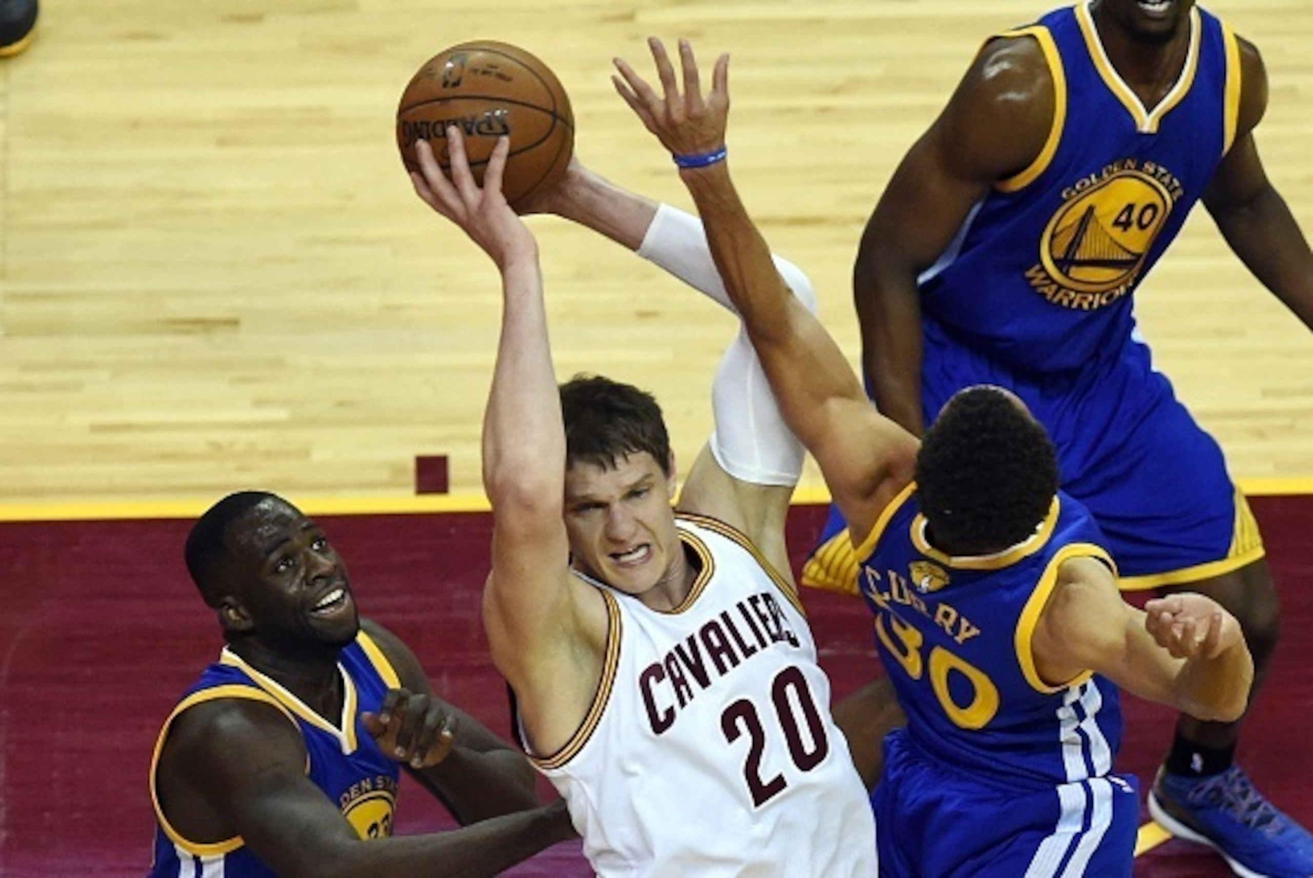 Golden State Warriors' Stephen Curry (R) and Draymond Green (L) defend against the Cleveland Cavaliers' Timofey Mozgov during Game 6 of the 2015 NBA Finals on June 16, 2015 at the Quicken Loans Arena in Cleveland, Ohio. AFP PHOTO  / TIMOTHY A. CLARY      