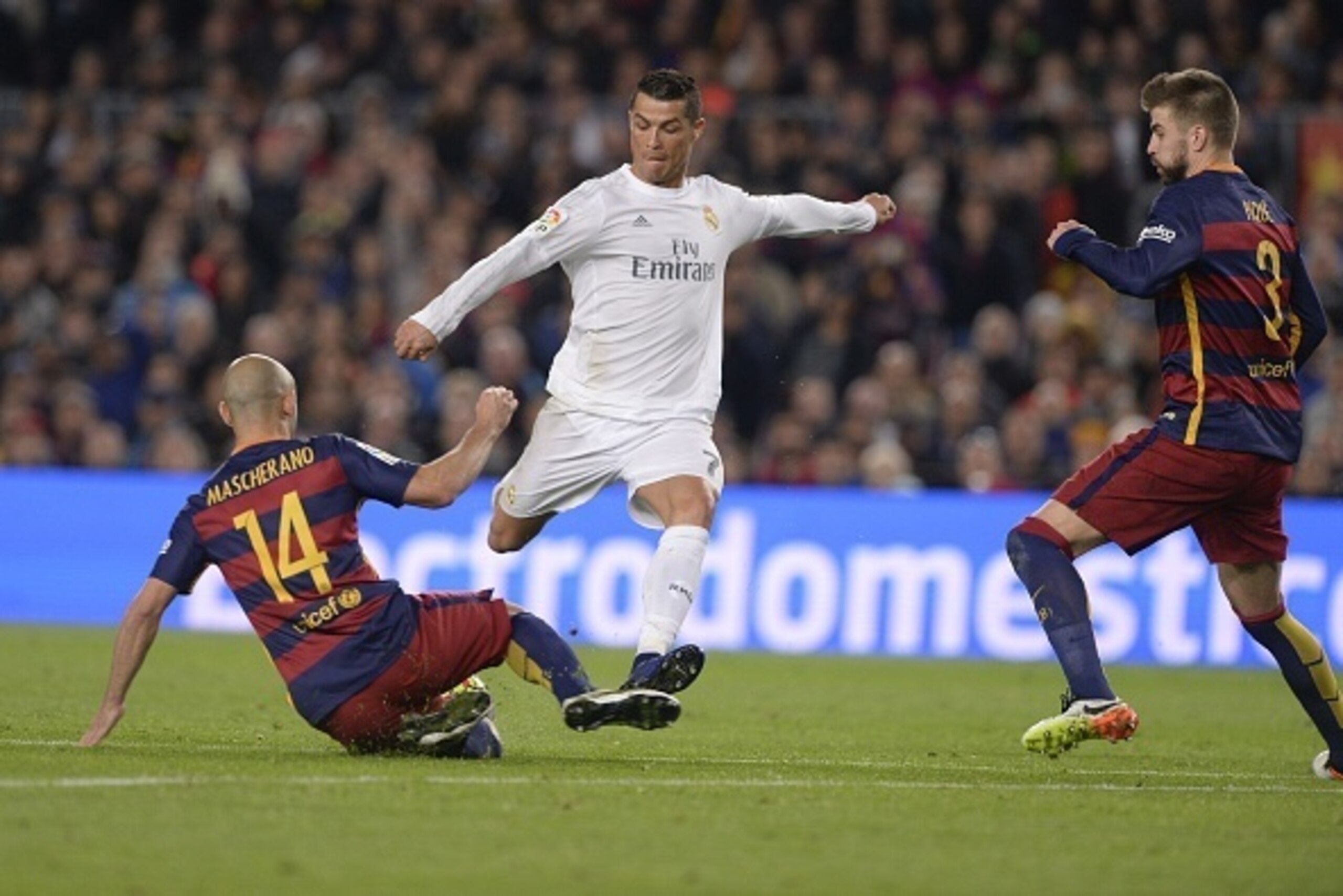 Real Madrid's Portuguese forward Cristiano Ronaldo (C) vies with Barcelona's defender Gerard Pique (R) and Barcelona's Argentinian defender Javier Mascherano during the Spanish league 'Clasico' football match FC Barcelona vs Real Madrid CF at the Camp Nou