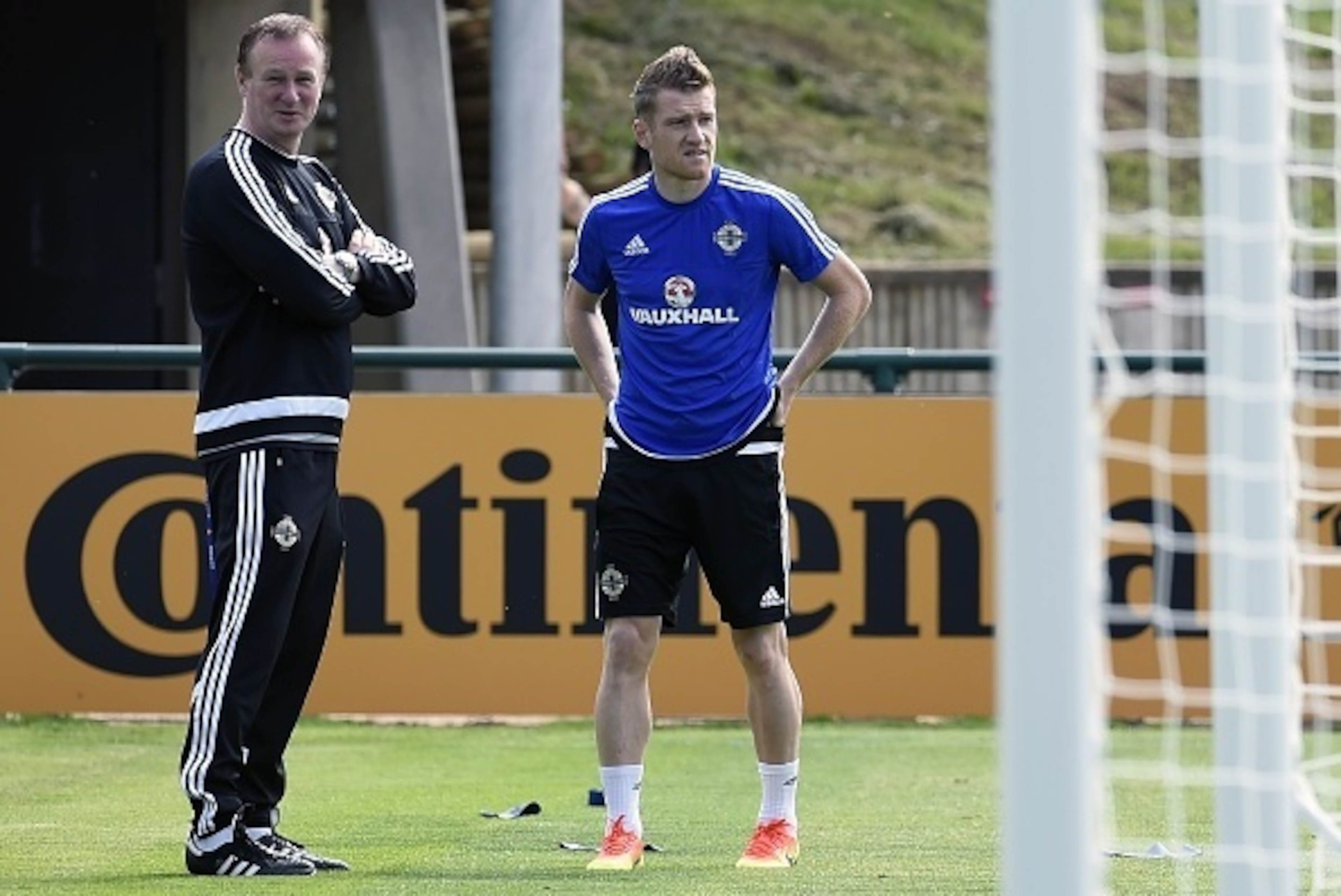 Northern Ireland's captain Steven Davis (L) and coach Michael O'Neill (L) attend a training session while water spray at their training ground in Saint George de Reneins on June 6, 2016 during the Euro 2016 football tournament. / AFP / PHILIPPE DESMAZES Northern Ireland's captain Steven Davis (L) and coach Michael O'Neill (L) attend a training session while water spray at their training ground in Saint George de Reneins on June 6, 2016 during the Euro 2016 football tournament. / AFP / PHILIPPE DESMAZES