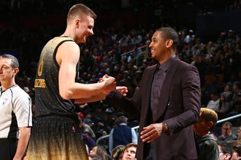 TORONTO, ON - FEBRUARY 12:  Kristaps Porzingis #6 of the World Team shakes hands with New York Knicks teammate Carmelo Anthony #7 during the game against the USA Team during the BBVA Compass Rising Stars Challenge as part of NBA All-Star 2016 on February