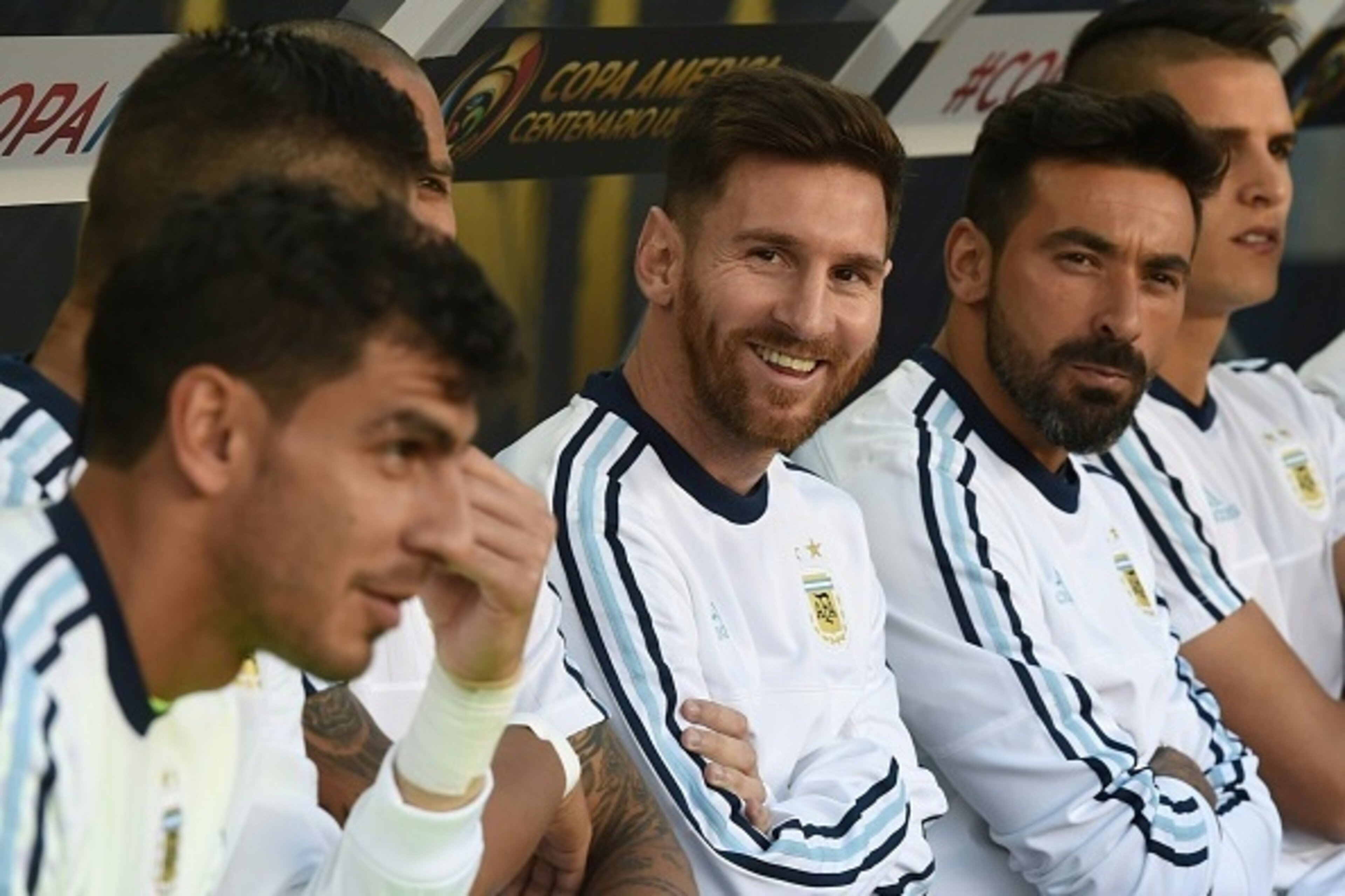 Argentina's Lionel Messi (C) smiles  from the bench next to teammate Ezequiel Lavezzi during a Copa America Centenario football match against Chile in Santa Clara, California, United States, on June 6, 2016.  / AFP / Mark Ralston        (Photo credit shou