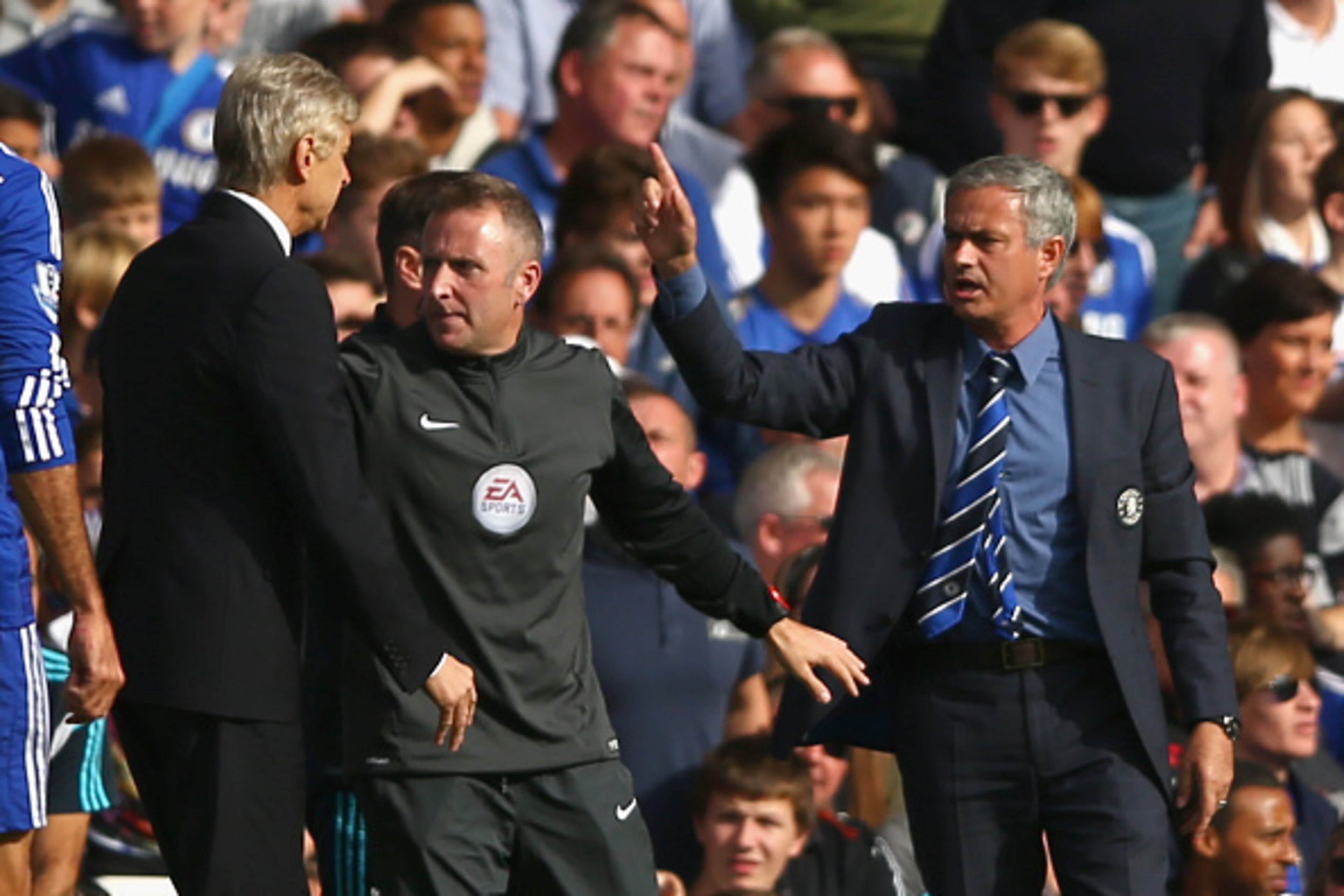LONDON, ENGLAND - OCTOBER 05:  Fourth Official Jonathan Moss comes between Managers Arsene Wenger of Arsenal and Jose Mourinho manager of Chelsea during the Barclays Premier League match between Chelsea and Arsenal at Stamford Bridge on October 4, 2014 in