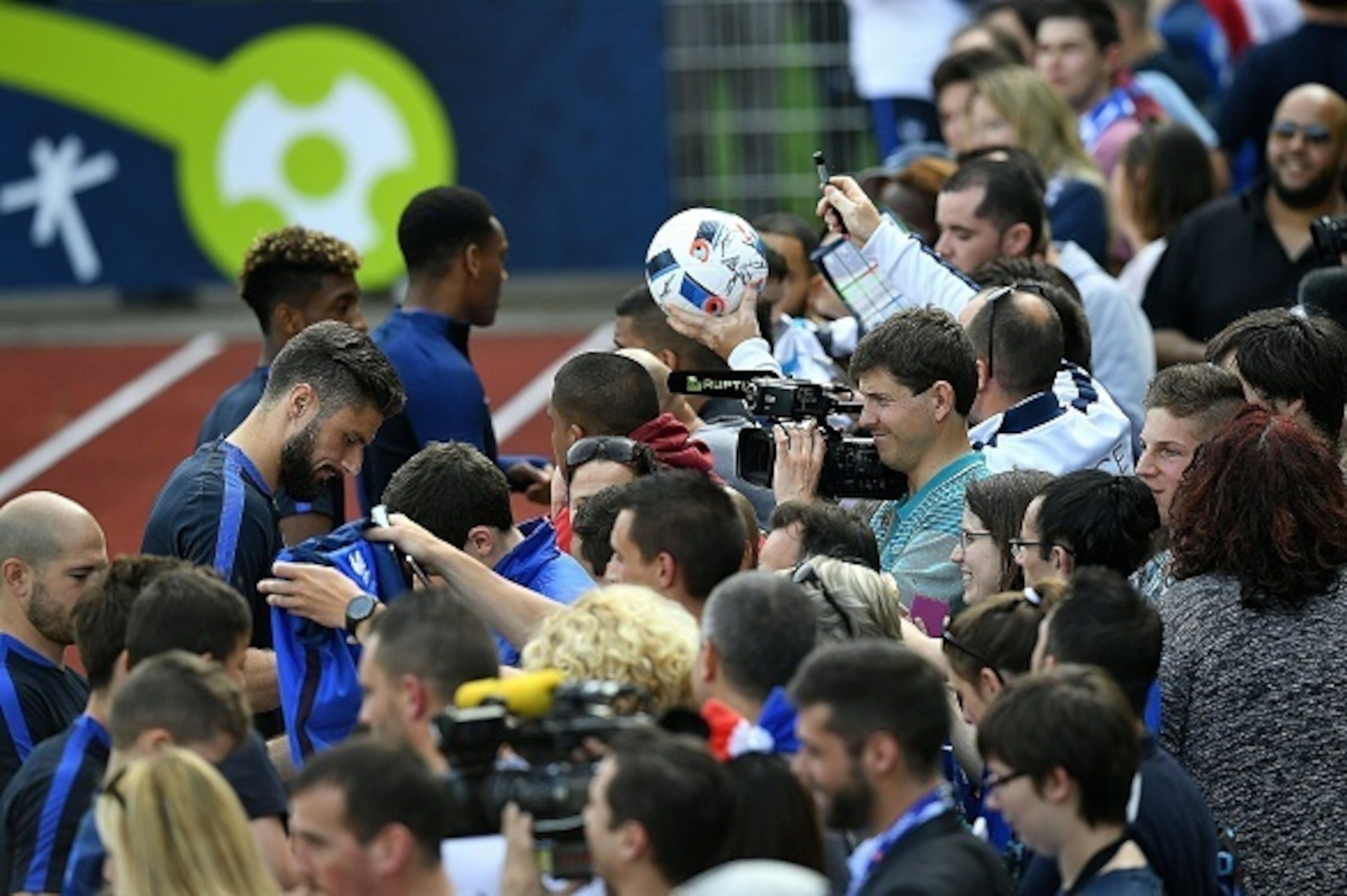 France's forward Olivier Giroud (C) and teammates sign autographs before a training session at their training ground in Clairefontaine-en-Yvelines, southwest of Paris, on June 6, 2016, ahead of the beginning of the Euro 2016 football tournament. / AFP / F
