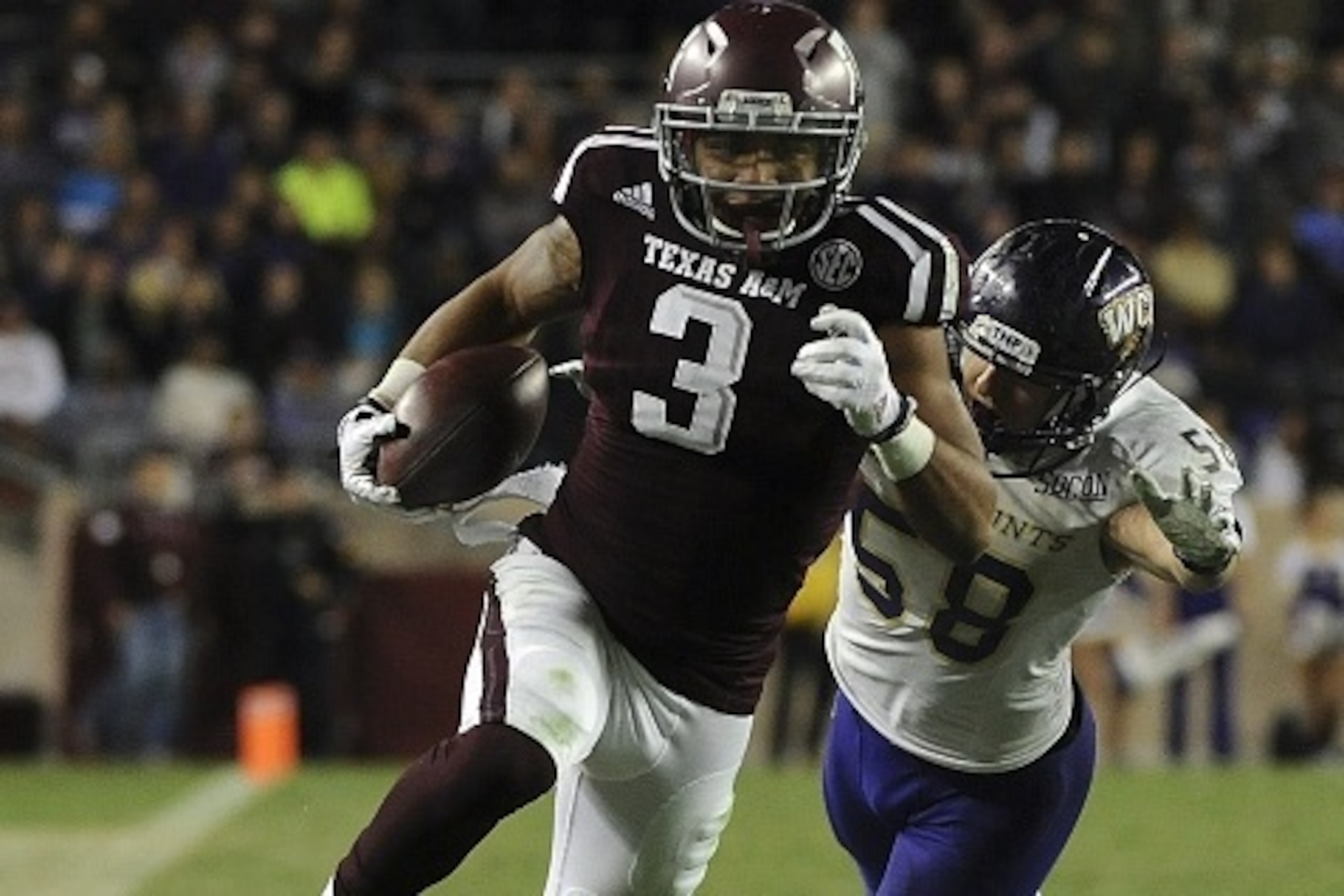 COLLEGE STATION, TX - NOVEMBER 14: Christian Kirk #3 of the Texas A&M Aggies avoids the tackle of Daniel Riddle #58 of the Western Carolina Catamounts for a 22-yard touchdown reception in the fourth quarter of a NCAA football game at Kyle Field on Novembe