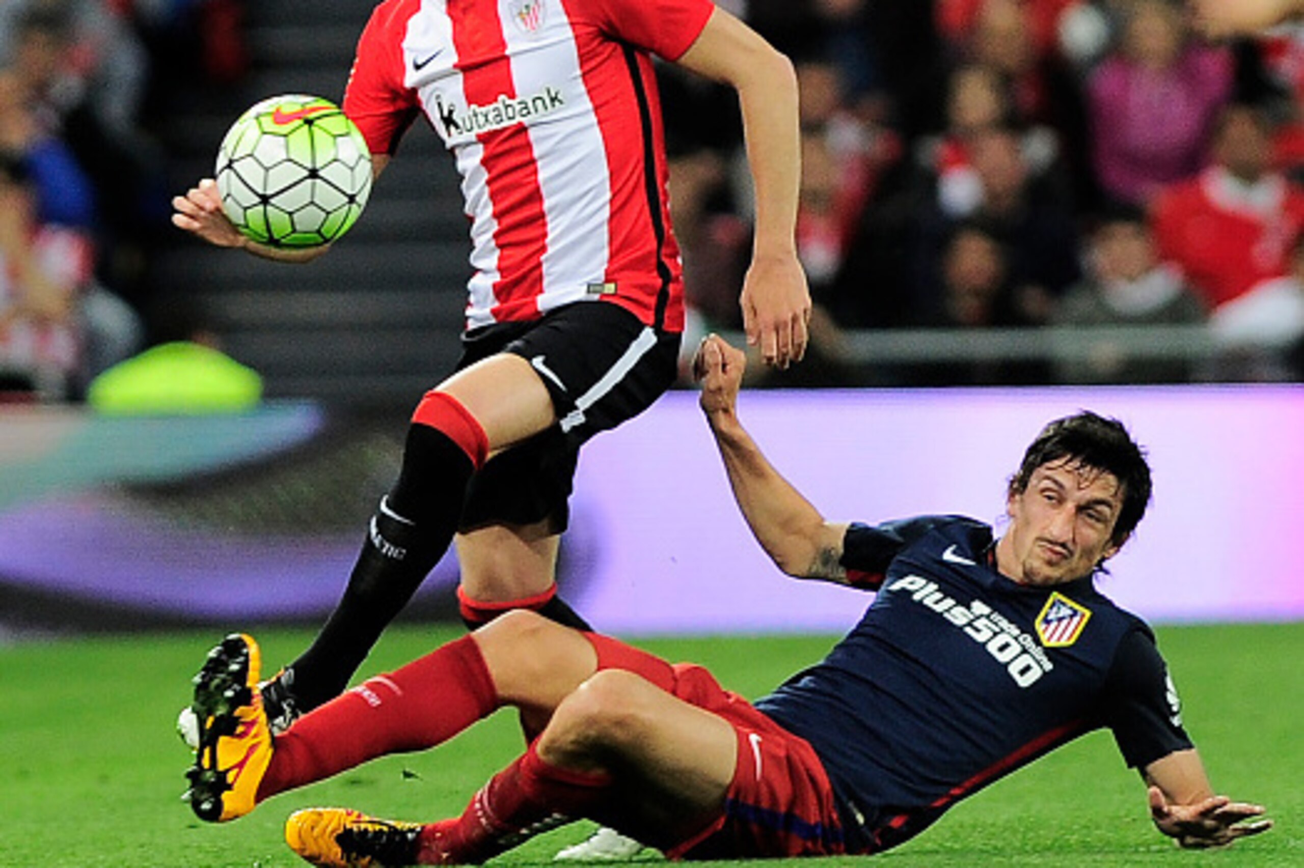 Athletic Bilbao's forward Borja Viguera Manzanares (L) vies with Atletico Madrid's Montenegrin defender Stefan Savic (R) during the Spanish league football match Athletic Club vs Atletico de Madrid at the San Mames stadium in Bilbao on April 20, 2016. / A