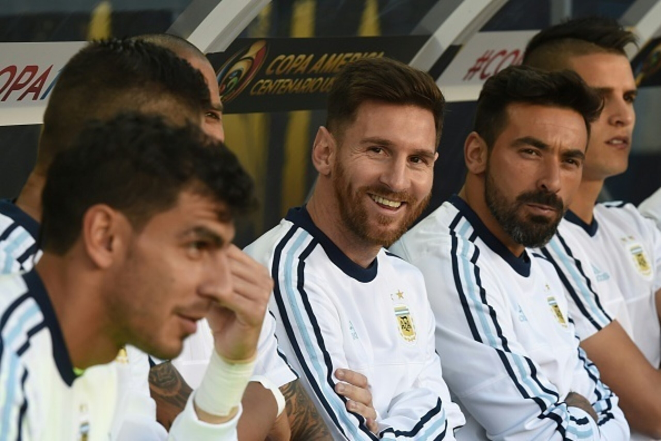 Argentina's Lionel Messi (C) smiles  from the bench next to teammate Ezequiel Lavezzi during a Copa America Centenario football match against Chile in Santa Clara, California, United States, on June 6, 2016.  / AFP / Mark Ralston        (Photo credit shou