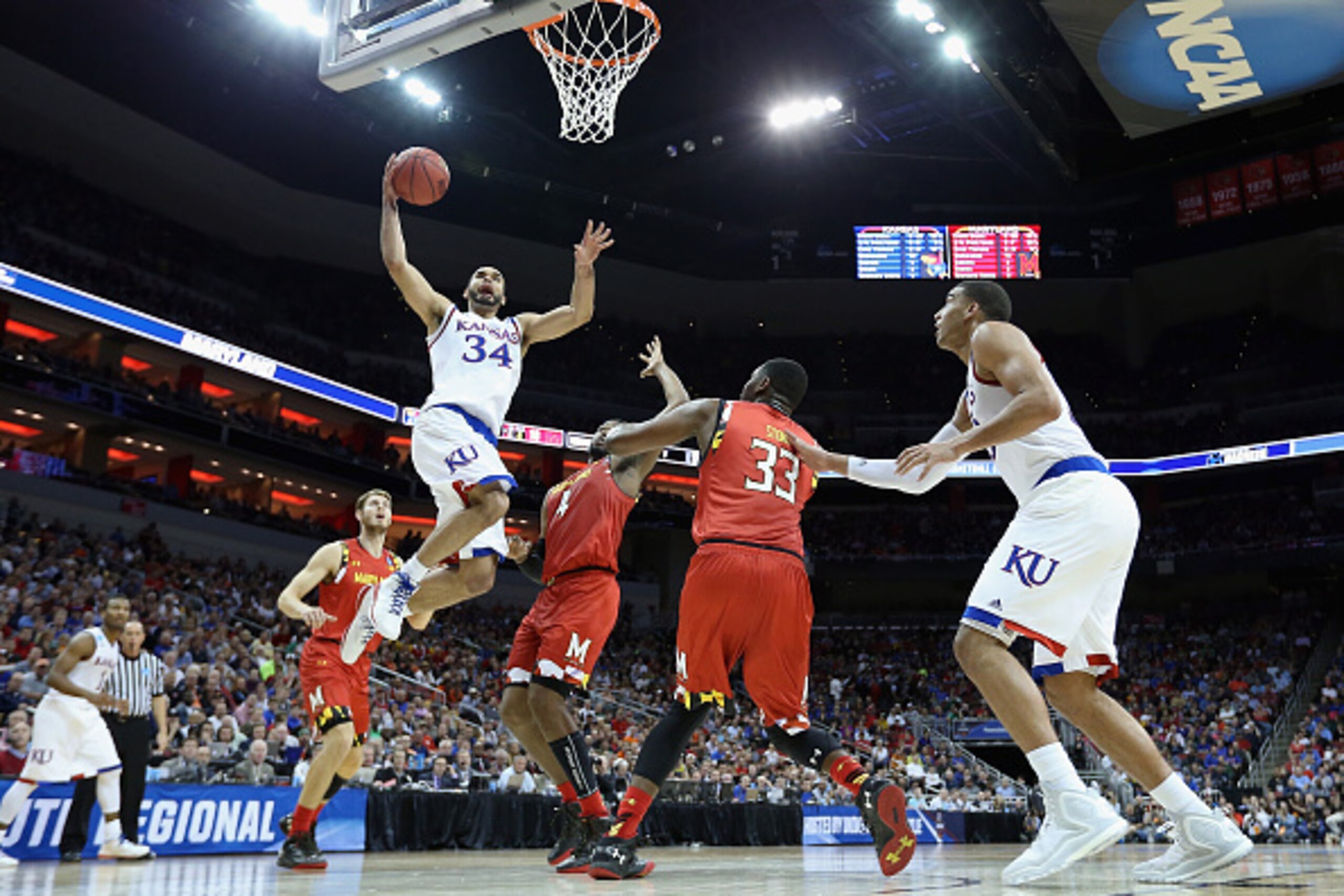 LOUISVILLE, KY - MARCH 24:  Perry Ellis #34 of the Kansas Jayhawks drives to the basket against Robert Carter #4 of the Maryland Terrapins and Diamond Stone #33 in the first half during the 2016 NCAA Men's Basketball Tournament South Regional at KFC YUM! 