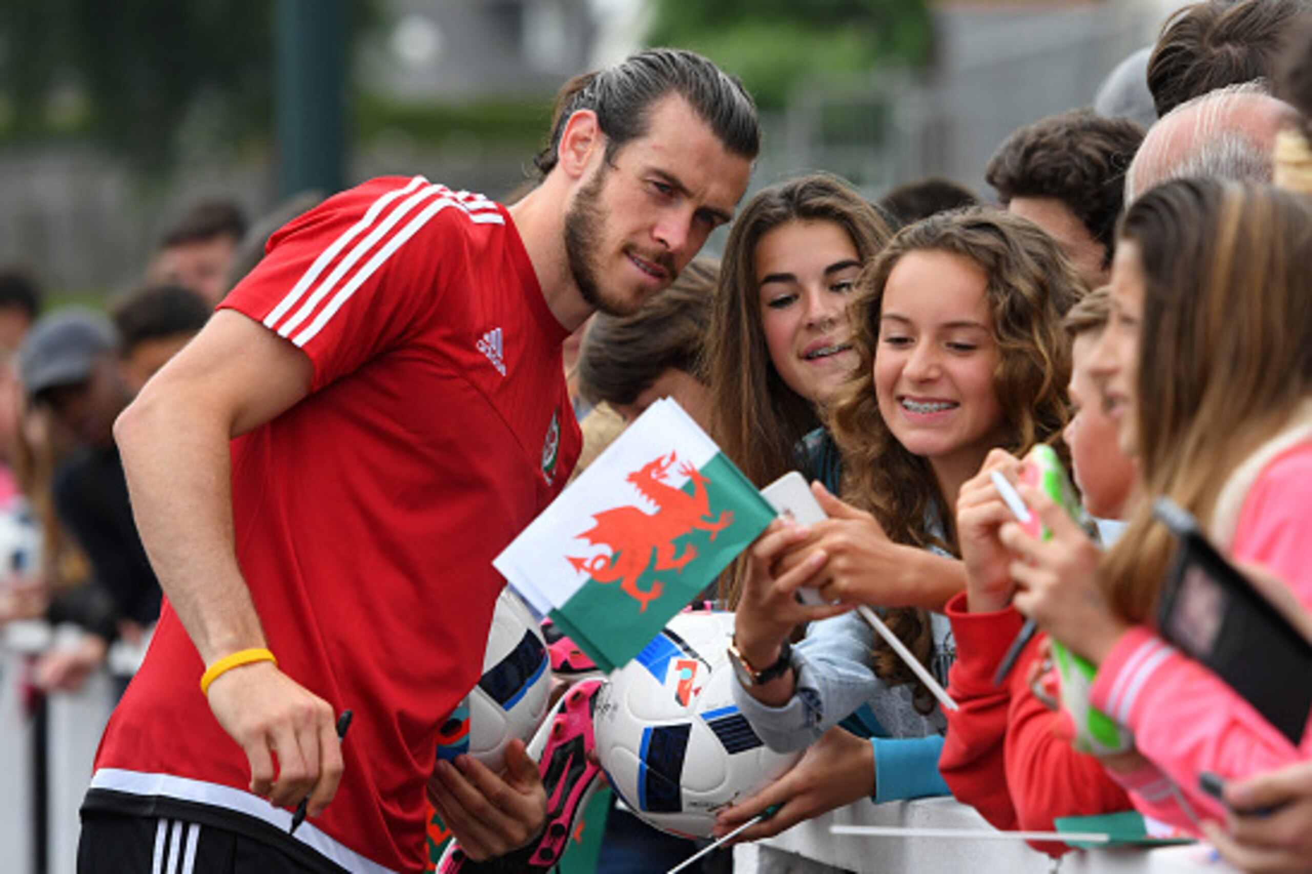 DINARD, FRANCE - JUNE 08:  Wales player Gareth Bale poses for selfies with local children after an open Euro 2016 Wales training session at the Wales training base on June 8, 2016 in Dinard, France.  (Photo by Stu Forster/Getty Images)