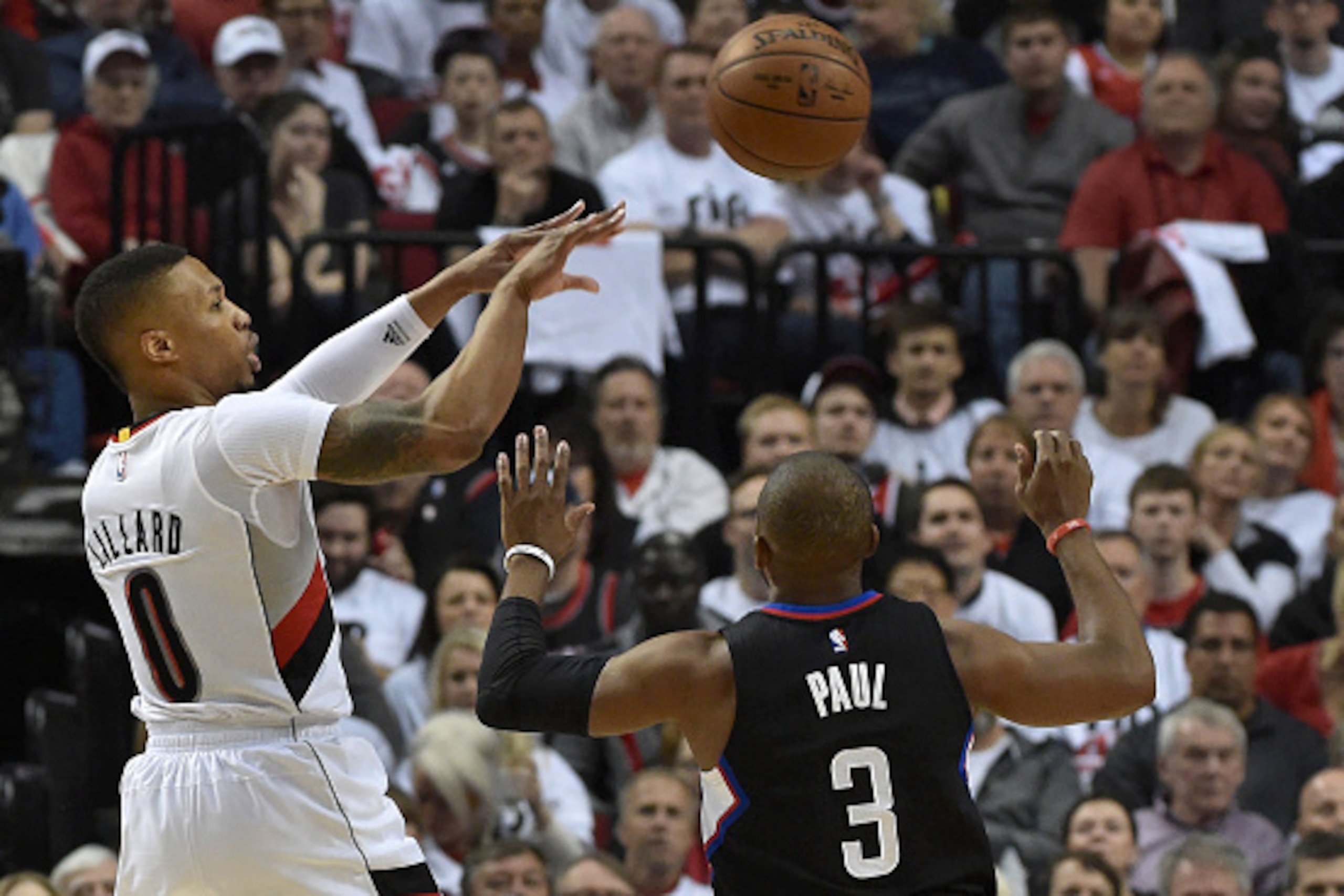 PORTLAND, OR - APRIL 25: Damian Lillard #0 of the Portland Trail Blazers passes the ball over Chris Paul #3 of the Los Angeles Clippers in the first quarter of Game Four of the Western Conference Quarterfinals during the 2016 NBA Playoffs at the Moda Cent