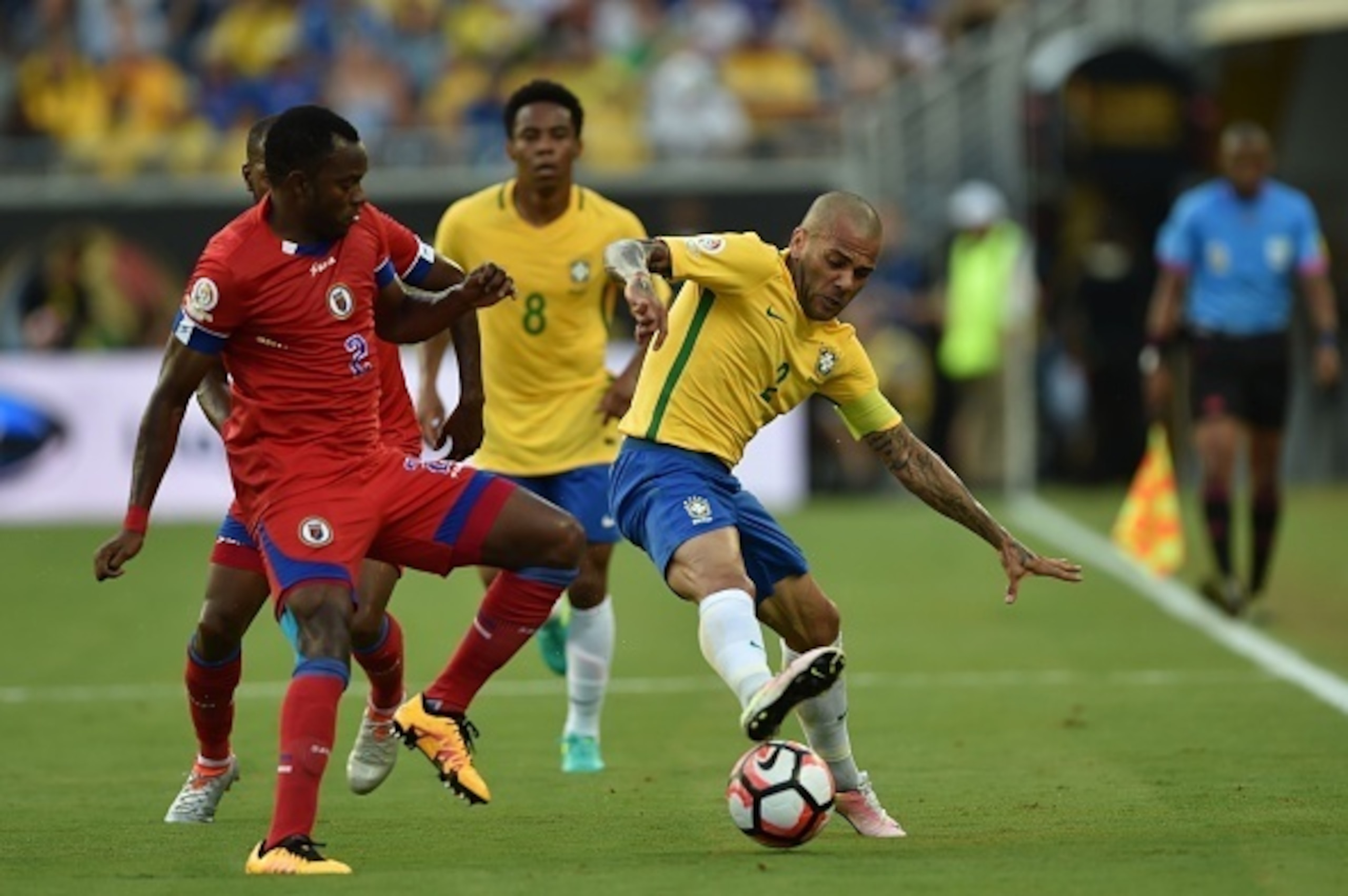 Haiti's Jean Sony Alcenat (L) vies for the ball with Brazil's Dani Alves (R) during a Copa America Centenario football match in Orlando, Florida, United States, on June 8, 2016.  / AFP / Hector RETAMAL        (Photo credit should read HECTOR RETAMAL/AFP/G