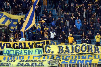 Supporters of Argentina's Rosario Central cheer for their team before the start of the Copa Libertadores Cup football match against Brazil's Gremio, at the Arena do Gremio stadium in Porto Alegre, Brazil, on April 27, 2016.   / AFP / JEFFERSON BERNARDES  