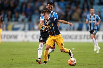 Argentina's Rosario Central Franco Cervi vies for the ball with Brazil's Gremio Maicon during their Copa Libertadores football match at Arena do Gremio stadium in Porto Alegre, Brazil, on April 27, 2016.   / AFP / JEFFERSON BERNARDES        (Photo credit 