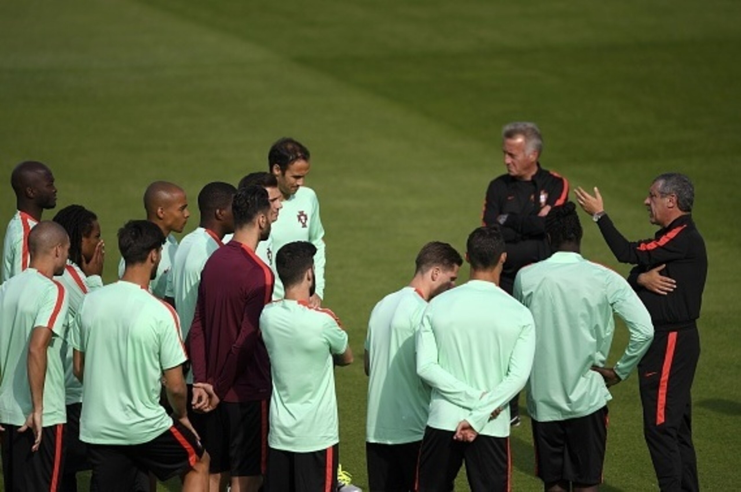 Portugal's coach Fernando Santos (R) speaks with his players during a training session at Portugal's base camp in Marcoussis, on June 9, 2016, one day prior to the beginning of the Euro 2016 football tournament. / AFP / Francisco LEONG        (Photo credi