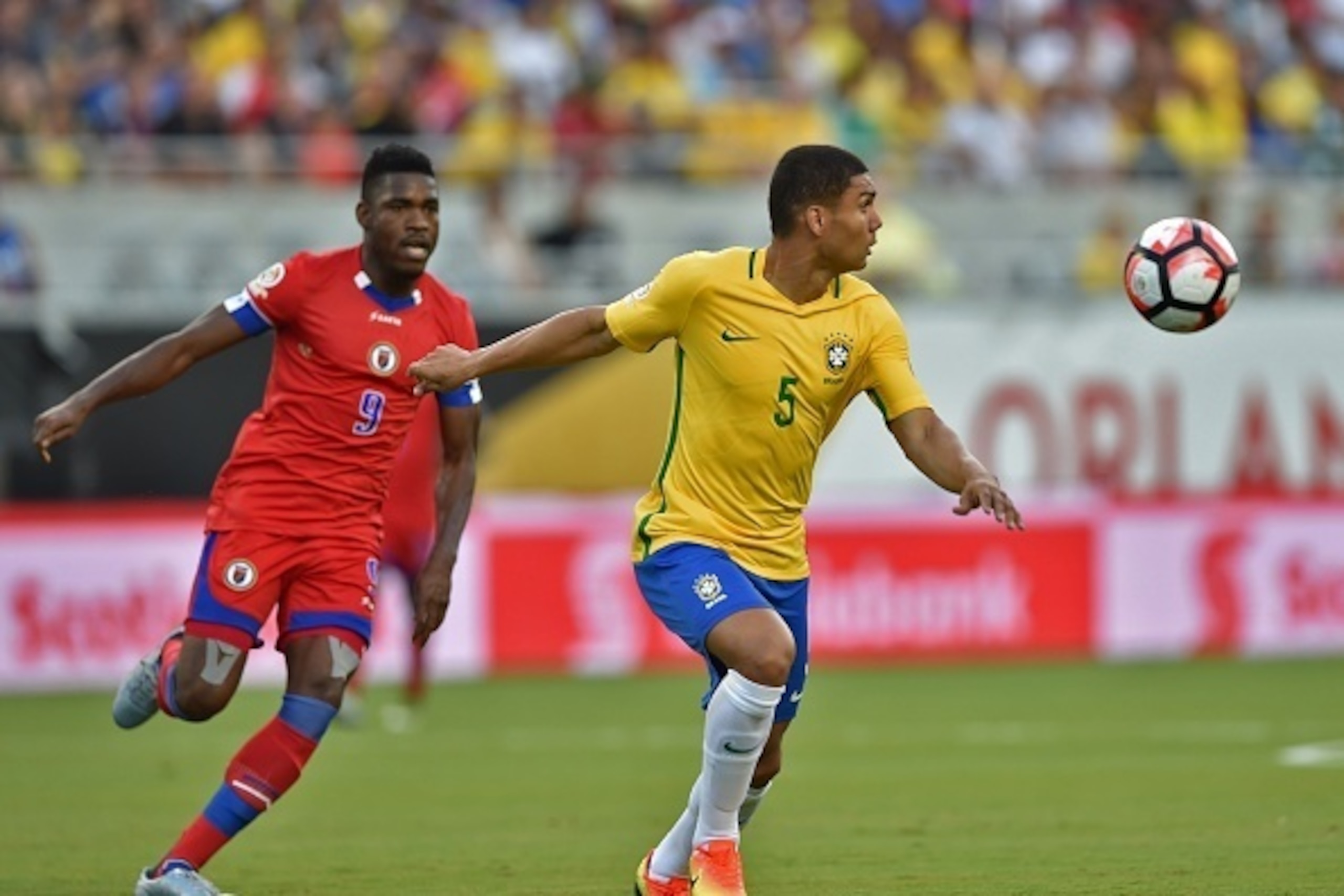 Brazil's Casemiro (R) vies for the ball with Haiti's Kervens Belfort during a Copa America Centenario football match in Orlando, Florida, United States, on June 8, 2016.  / AFP / Hector RETAMAL        (Photo credit should read HECTOR RETAMAL/AFP/Getty Ima