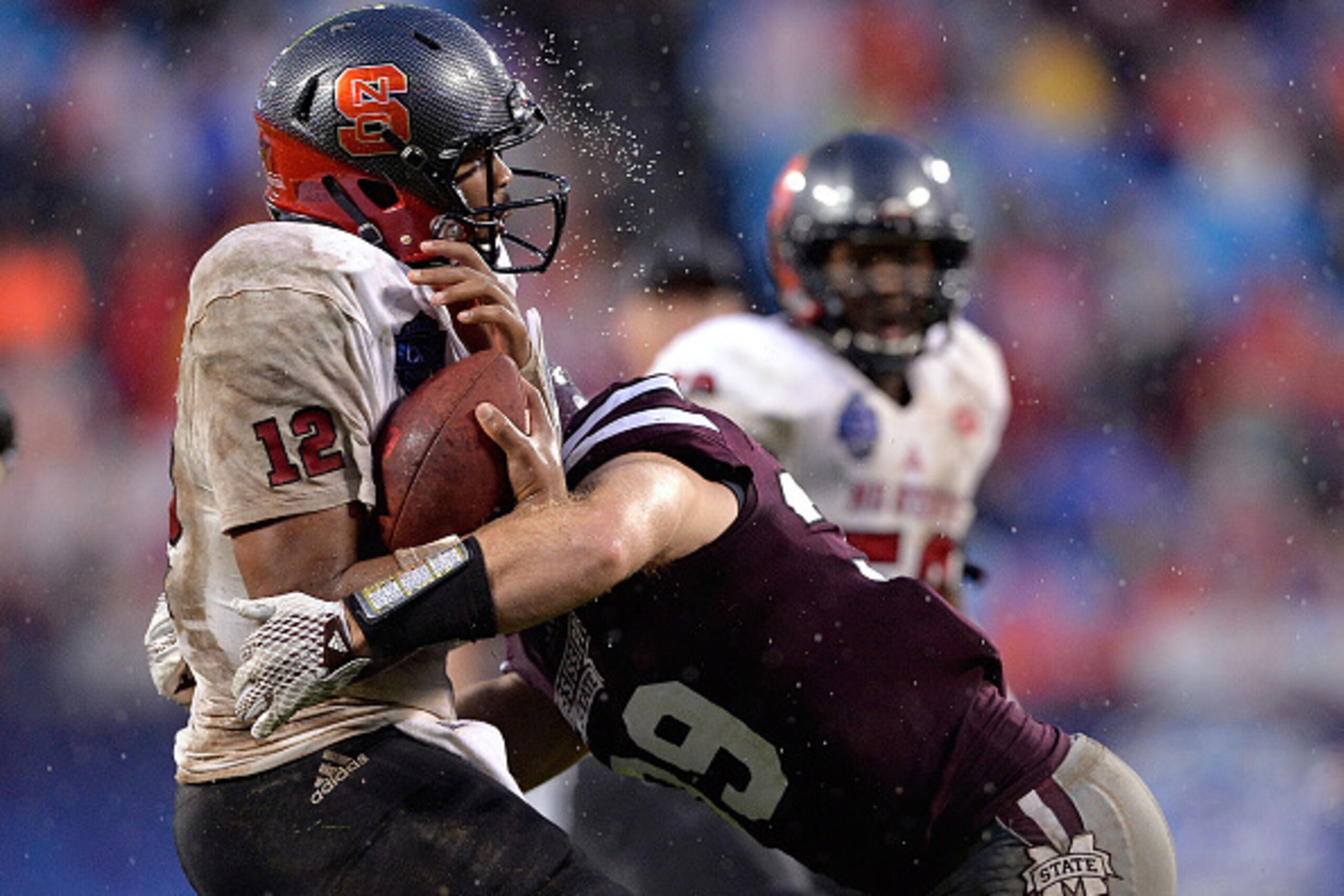 CHARLOTTE, NC - DECEMBER 30:  Richie Brown #39 of the Mississippi State Bulldogs sacks Jacoby Brissett #12 of the North Carolina State Wolfpack during the Belk Bowl at Bank of America Stadium on December 30, 2015 in Charlotte, North Carolina.  (Photo by G