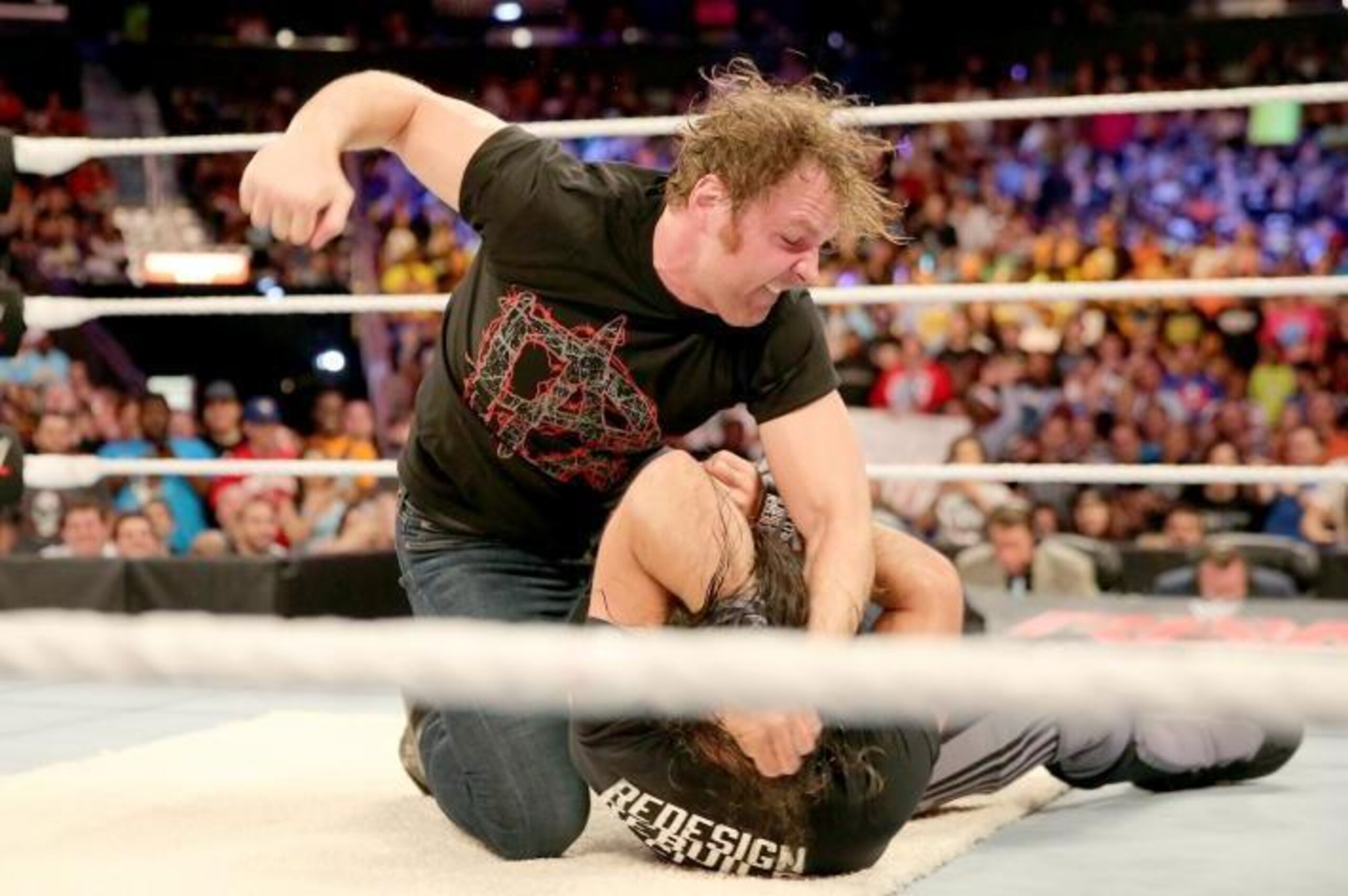 Dean Ambrose pounces on Seth Rollins.