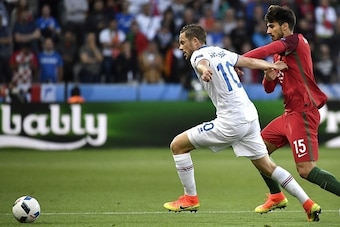 Iceland's midfielder Gylfi Sigurdsson (L) is tackled by Portugal's midfielder Andre Gomes during the Euro 2016 group F football match between Portugal and Iceland at the Geoffroy-Guichard stadium in Saint-Etienne on June 14, 2016. / AFP / jeff pachoud    