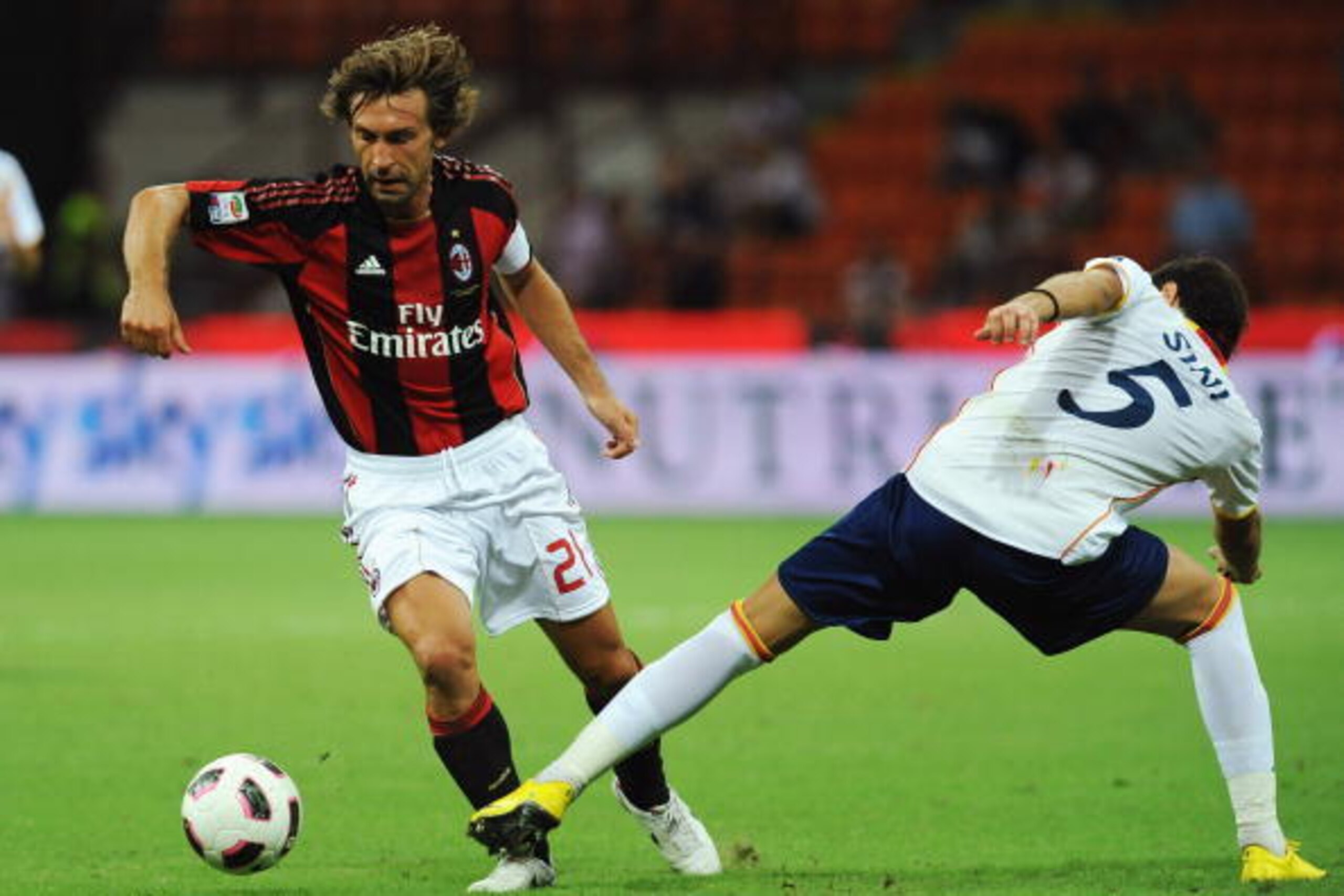 MILAN, ITALY - AUGUST 29:  Andrea Pirlo of AC Milan is challenged by Simone Sini of US Lecce during the Serie A match between AC Milan and US Lecce at Stadio Giuseppe Meazza on August 29, 2010 in Milan, Italy.  (Photo by Valerio Pennicino/Getty Images)