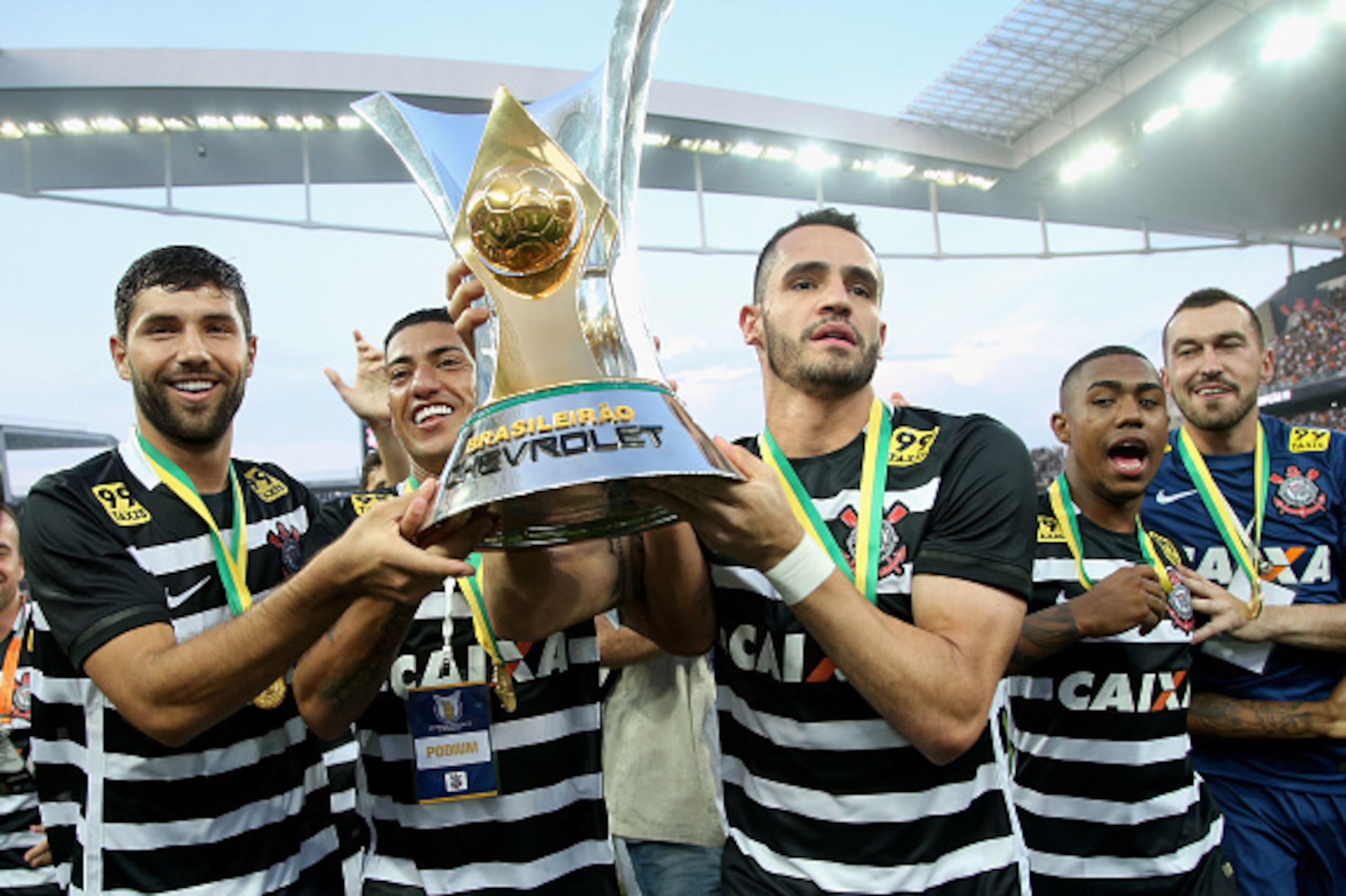SAO PAULO, BRAZIL - NOVEMBER 22:  Felipe, Ralf and Renato Augusto of Corinthians celebrates with the trophy after winning the match between Corinthians and Sao Paulo for the Brazilian Series A 2015 at Arena Corinthians on November 22, 2015 in Sao Paulo, B