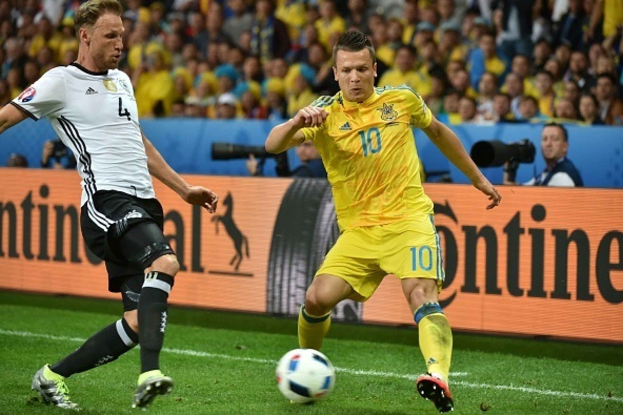 Germany's defender Benedikt Hoewedes (L) challenges Ukraine's midfielder Yevhen Konoplyanka during the Euro 2016 group C football match between Germany and Ukraine at the Stade Pierre Mauroy in Villeneuve-d'Ascq near Lille on June 12, 2016. / AFP / PHILIP