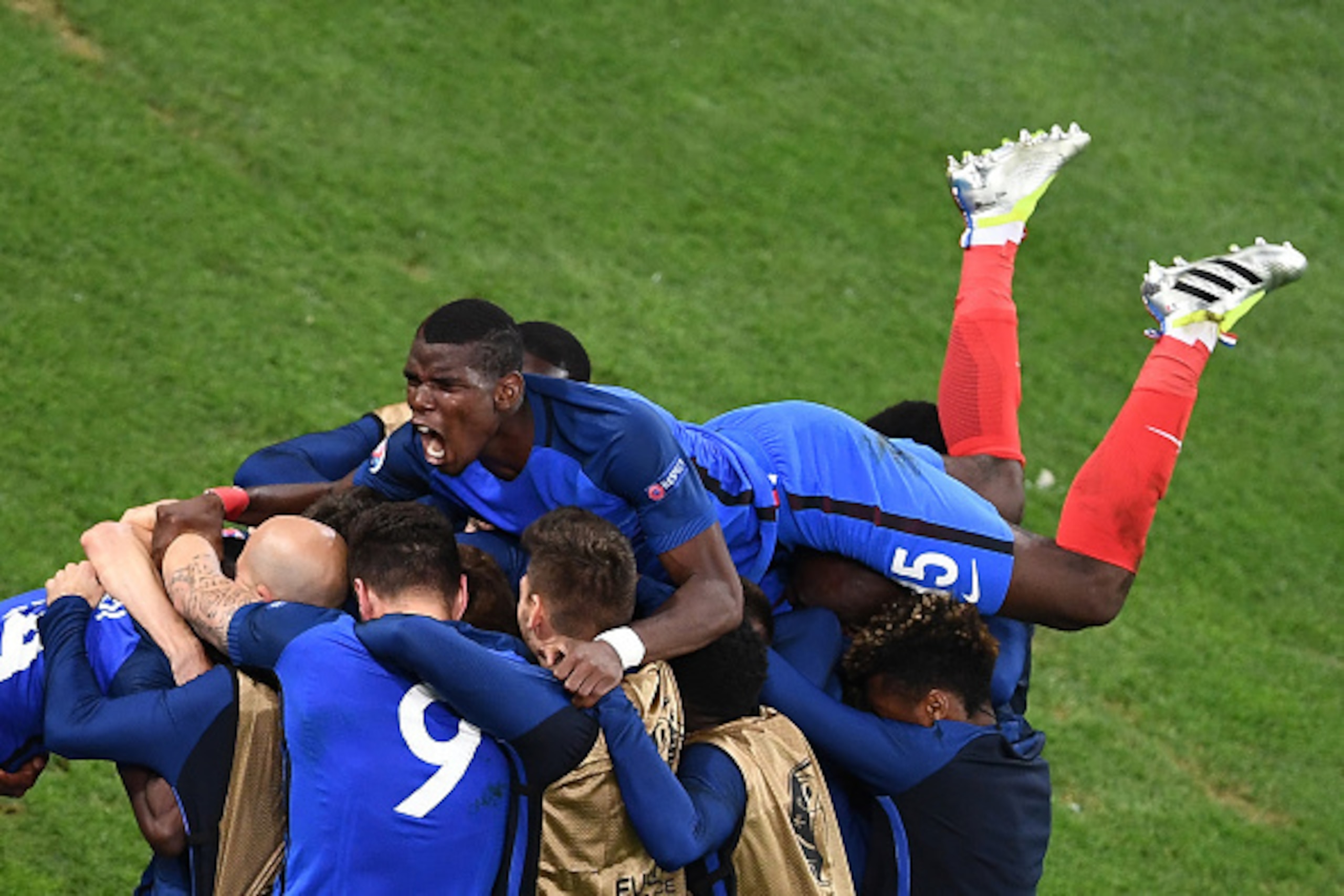 France's midfielder Paul Pogba (top) and his teammates celebrate after the team scored during the Euro 2016 group A football match between France and Albania at the Velodrome stadium in Marseille on June 15, 2016. / AFP / ANNE-CHRISTINE POUJOULAT        (