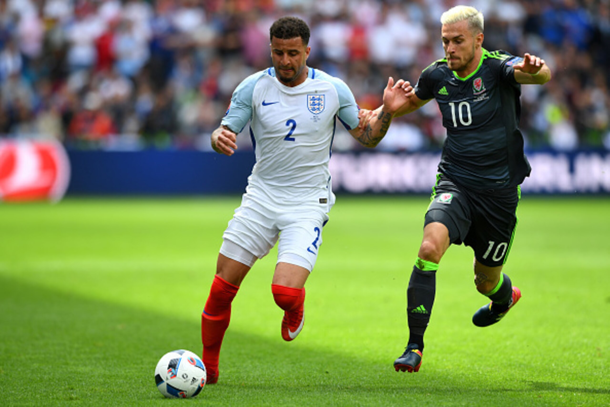 LENS, FRANCE - JUNE 16: Kyle Walker of England bursts past Aaron Ramsey of Wales during the UEFA Euro 2016 Group B match between England and Wales at Stade Bollaert-Delelis on June 16, 2016 in Lens, France.  (Photo by Stu Forster/Getty Images)