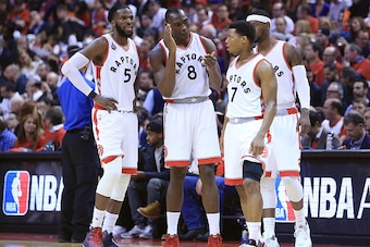 TORONTO, ON - APRIL 26:  Bismack Biyombo #8 of the Toronto Raptors talks with teammates DeMarre Carroll #5, Kyle Lowry #7 and Terrance Ross #31 in the first half of Game Five of the Eastern Conference Quarterfinals against the Indiana Pacers during the 20