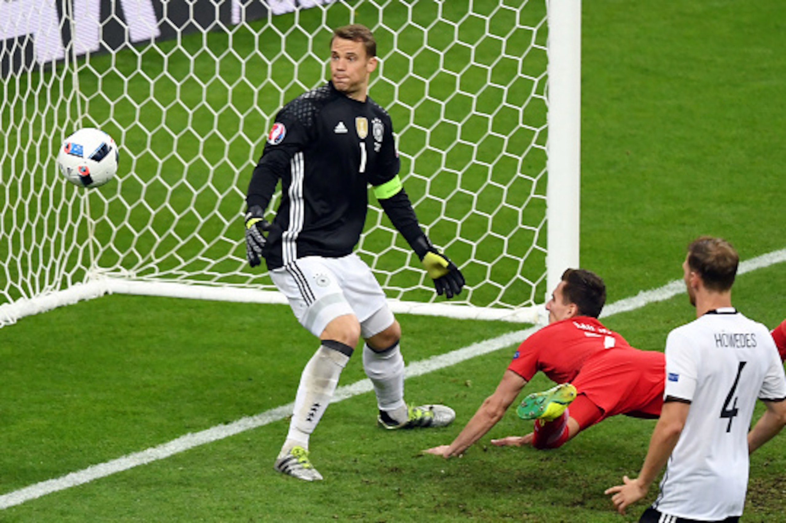 Poland's forward Arkadiusz Milik (Below) challenges the Germany goal line during the Euro 2016 group C football match between Germany and Poland at the Stade de France stadium in Saint-Denis near Paris on June 16, 2016. / AFP / FRANCISCO LEONG        (Pho