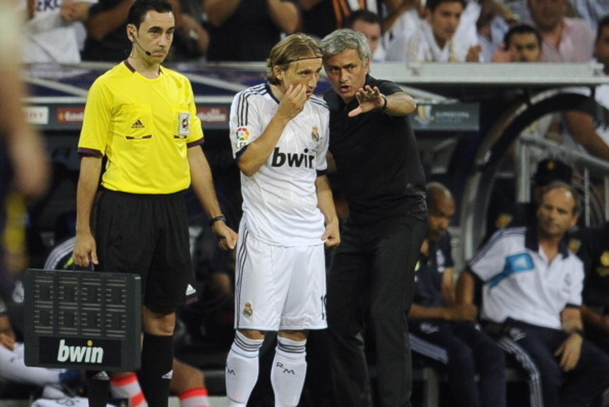 Real Madrid's Croatian midfielder Luka Modric (C) listens to his coach Jose Mourinho (R) during the second leg of the Spanish Supercup football match Real Madrid CF vs FC Barcelona on August 29, 2012 at the Santiago Bernabeu stadium in Madrid.    AFP PHOT