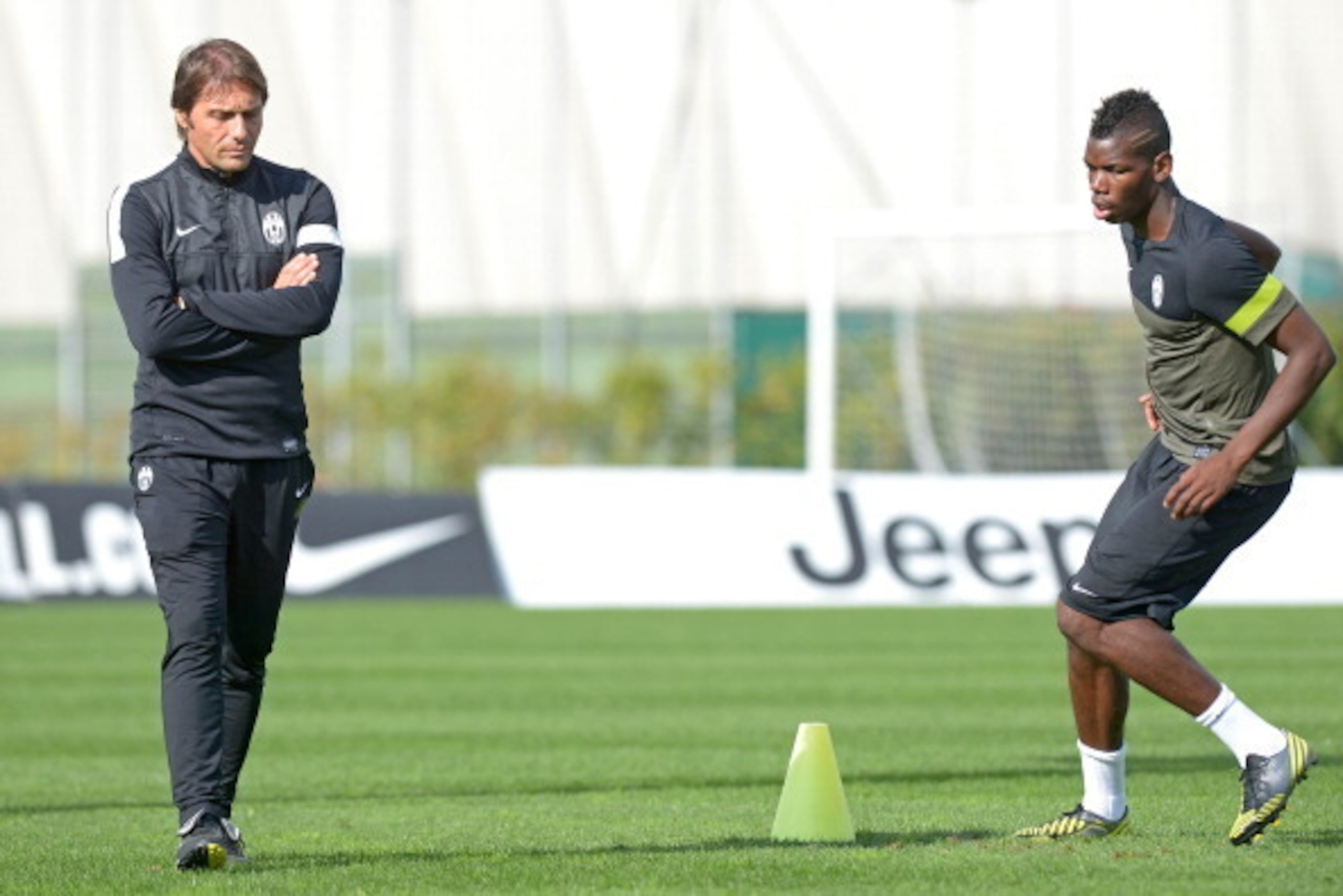 Juventus' coach Antonio Conte (L) walks past Juventus' French midfielder Paul Pogba during a training session on the eve of their Champions League match against Shakhtar Donetsk on October 1, 2012 in Turin.  AFP PHOTO / FILIPPO ALFERO        (Photo credit