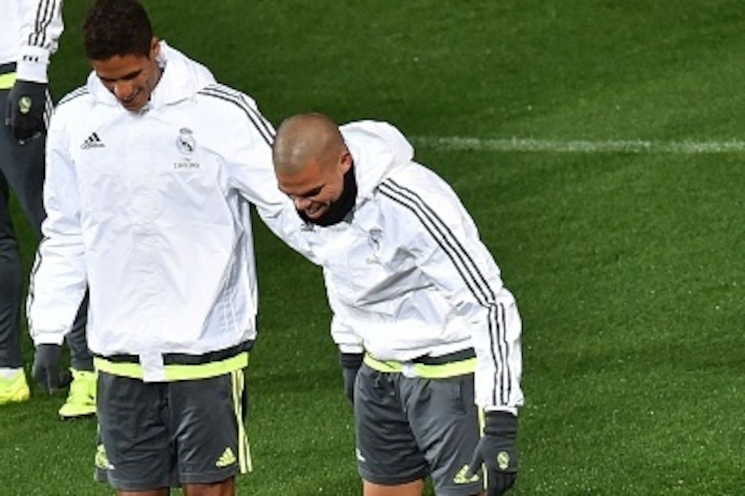 Real Madrid defenders Raphael Varane (L) and Pepe (R) share a smile as Cristiano Ronaldo (C) gestures on the ground after falling during a training session ahead of the International Champions Cup football tournament in Melbourne on July 14, 2015.   AFP P