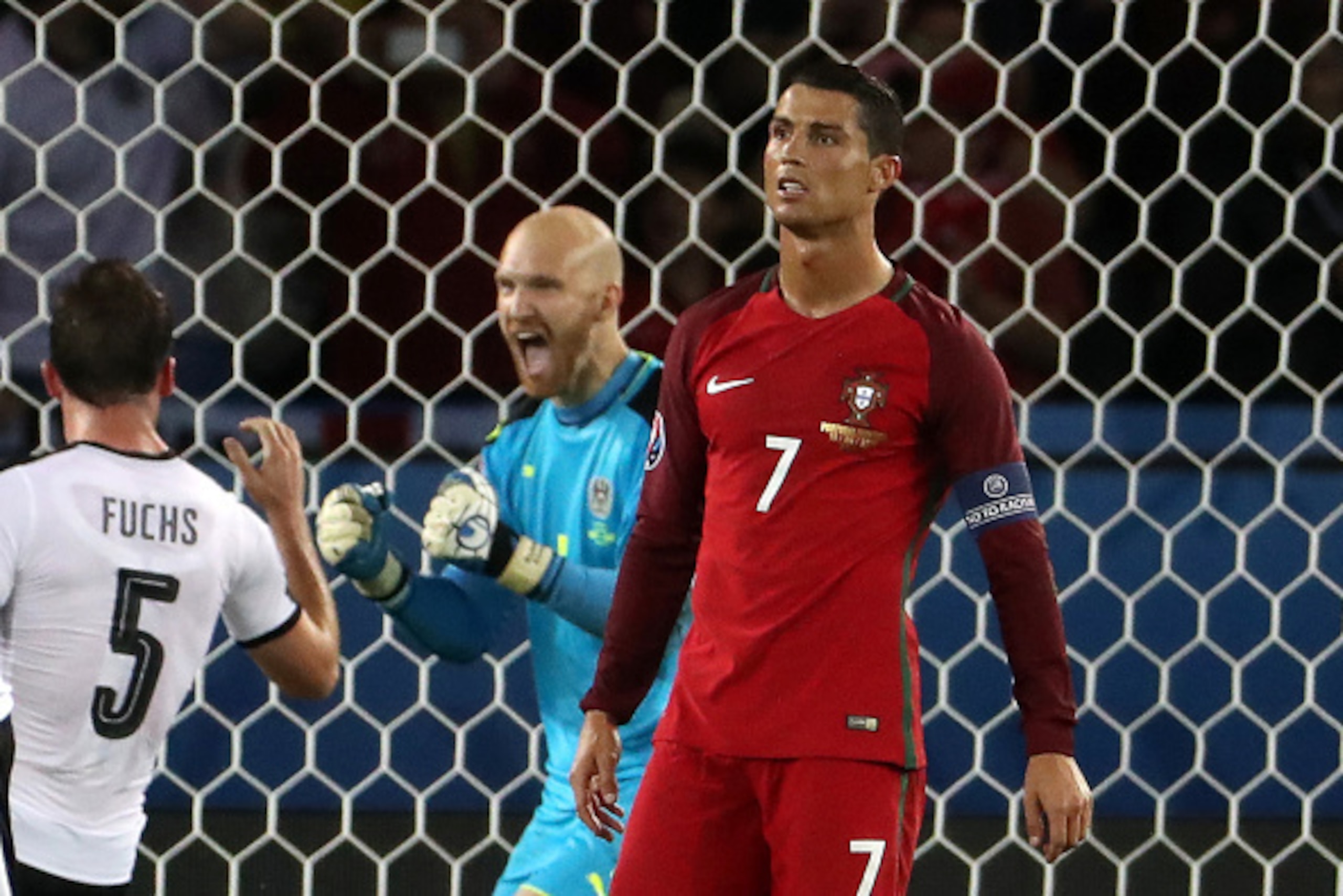 Portugal's forward Cristiano Ronaldo (R) reacts after missing a penalty kick while Austria's goalkeeper Robert Almer (C) and Austria's defender Christian Fuchs celebrate it during the Euro 2016 group F football match between Portugal and Austria at the Pa