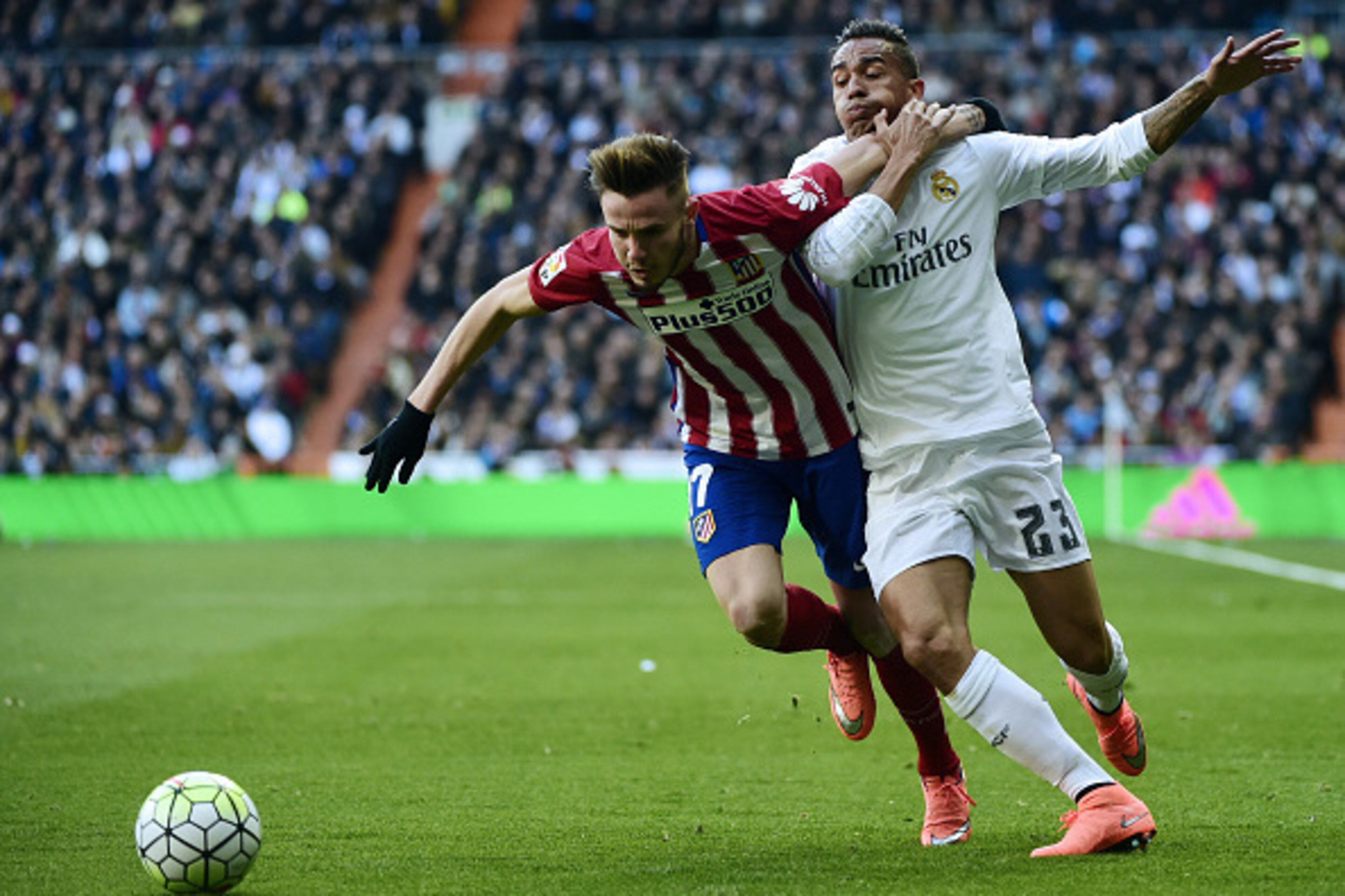 Real Madrid's Brazilian defender Danilo (R) vies with Atletico Madrid's midfielder Saul Niguez during the Spanish league football match Real Madrid CF vs Club Atletico de Madrid at the Santiago Bernabeu stadium in Madrid on February 27, 2016. / AFP / PIER