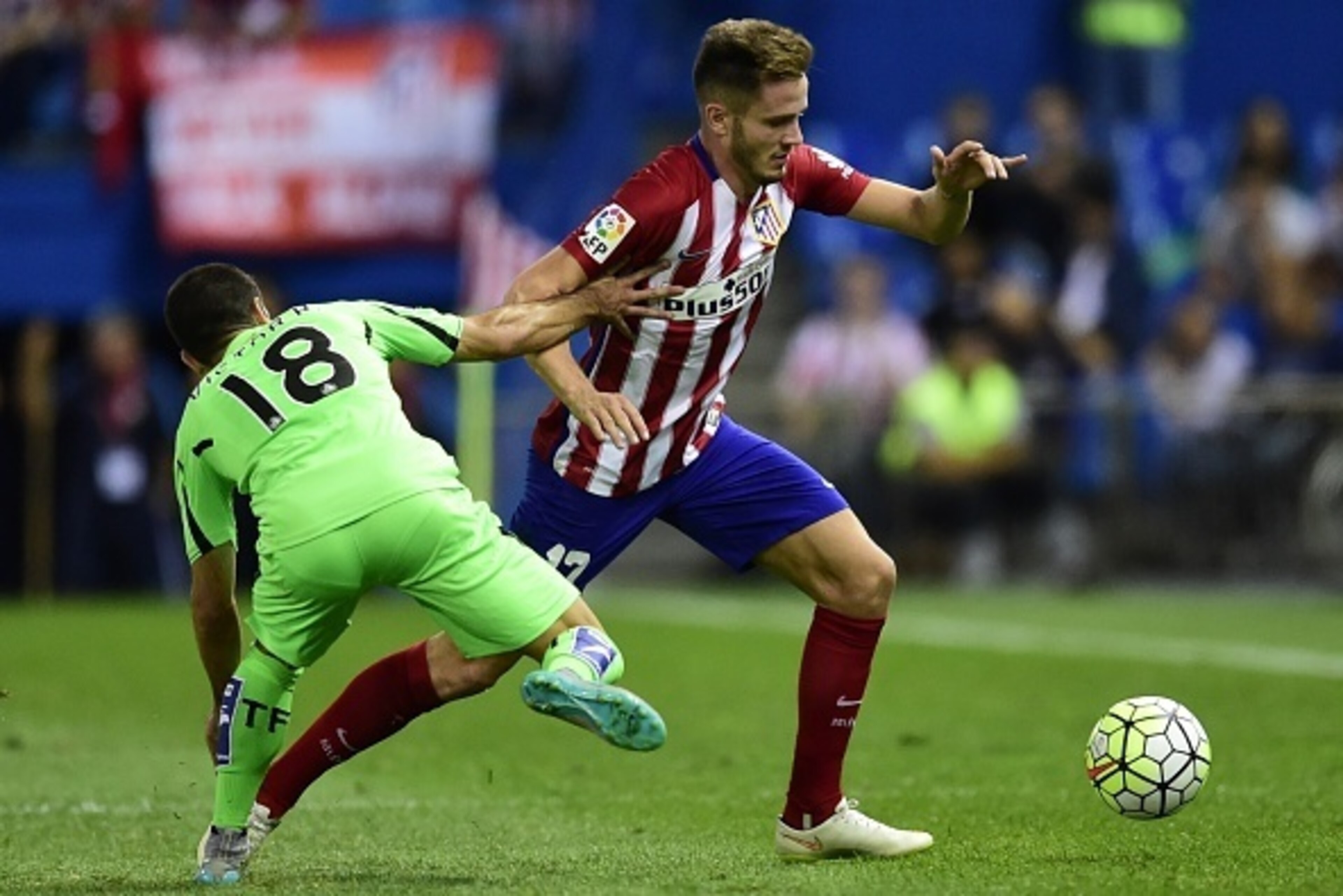 Atletico Madrid's midfielder Saul Niguez (R) vies with Getafe's midfielder Victor Rodriguez during the Spanish league football match Club Atletico de Madrid vs Getafe CF at the Vicente Calderon stadium in Madrid on September 22, 2015.   AFP PHOTO/ JAVIER 