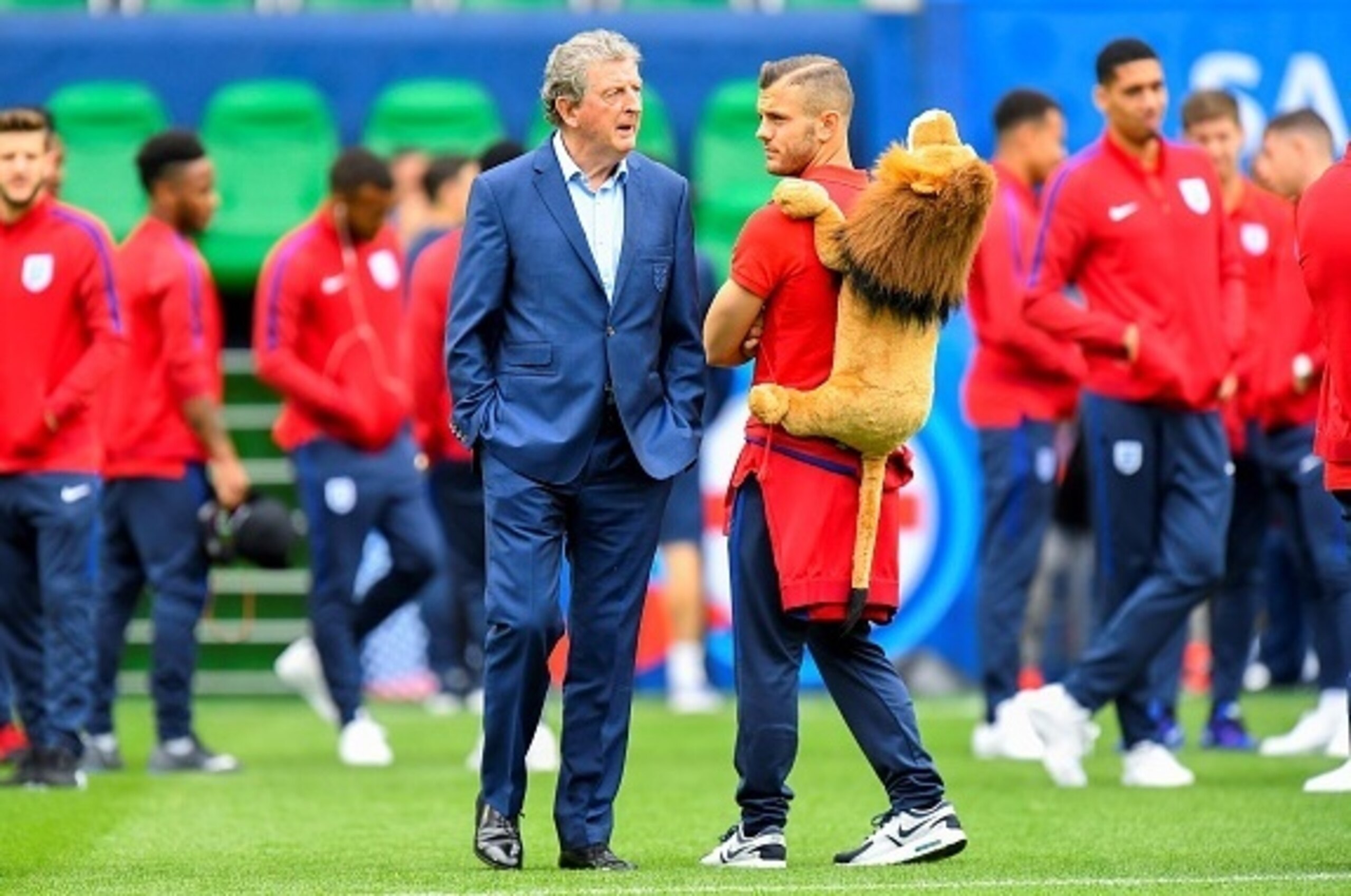 England's head coach Roy Hodgson (L) speaks to midfielder Jack Wilshere while they check a pitch on the eve of their match against Slovakia in Saint Etienne on June 19, 2016, during the the Euro 2016 football tournament.  / AFP / JOE KLAMAR        (Photo 