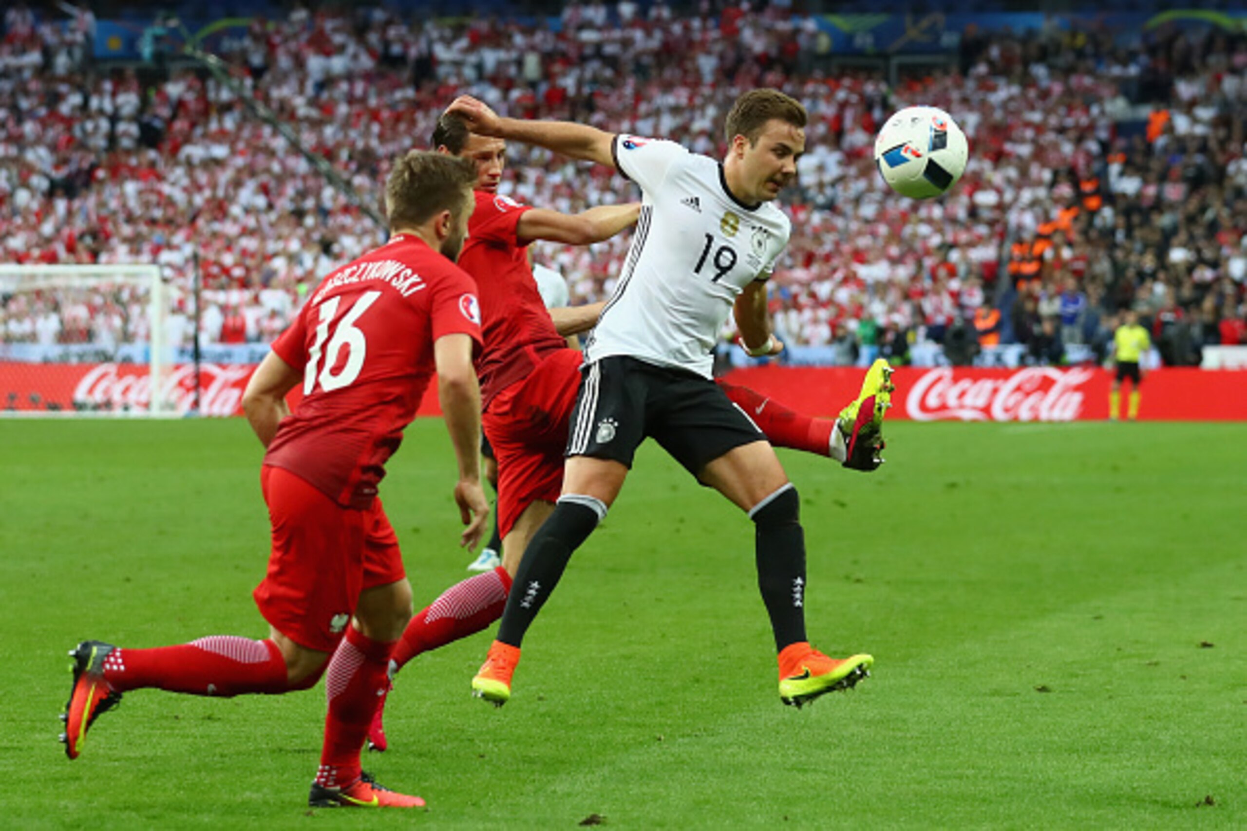 PARIS, FRANCE - JUNE 16:  Mario Goetze (R) of Germany battles for the ball with Jakub Blaszczykowski (L) of Poland and his team mate Grzegorz Krychowiak during the UEFA EURO 2016 Group C match between Germany and Poland at Stade de France on June 16, 2016